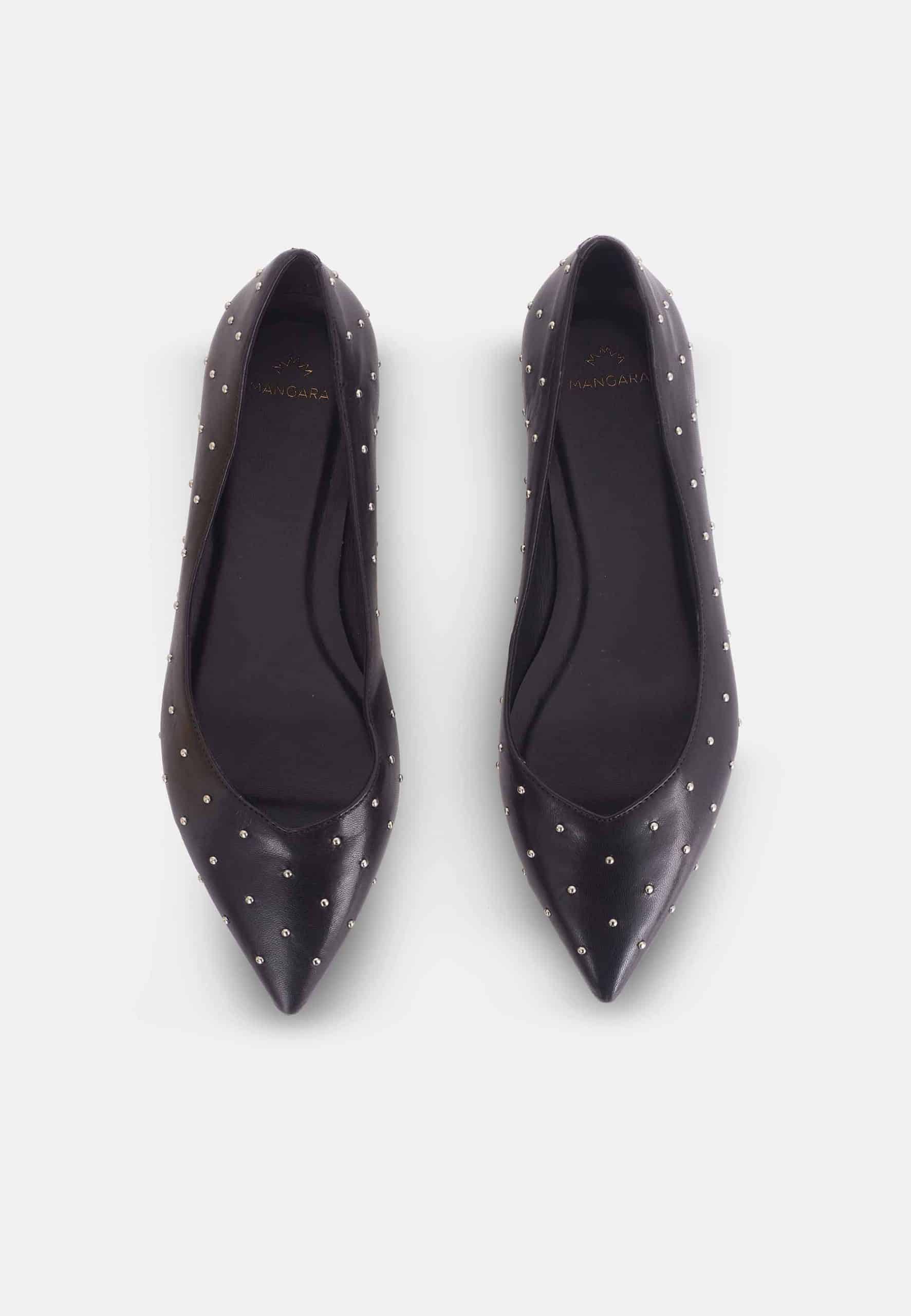 Pair of black pointed-toe shoes with studded details on a white background