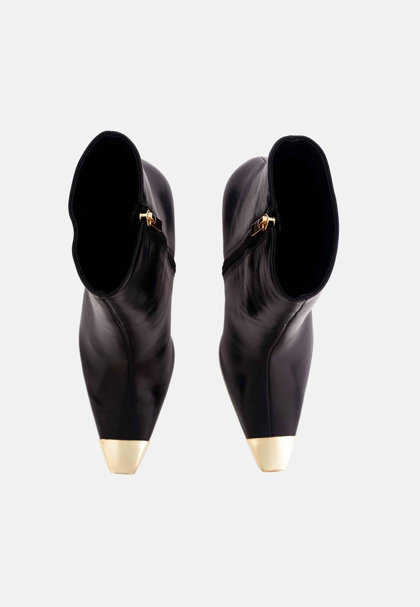 Pair of black high-heeled shoes with gold toes on a white background