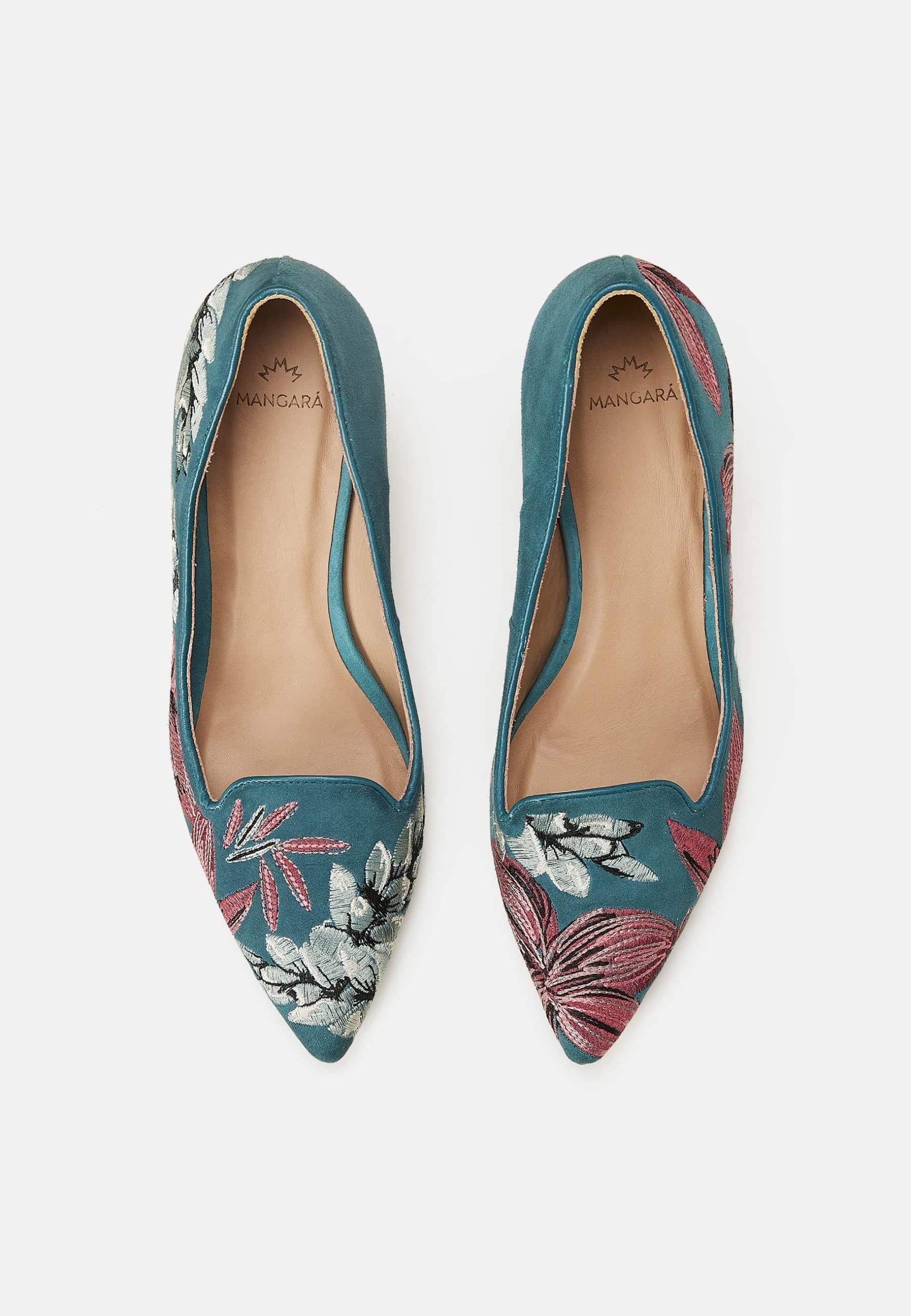 Pair of teal pointed-toe shoes with floral embroidery on a white background