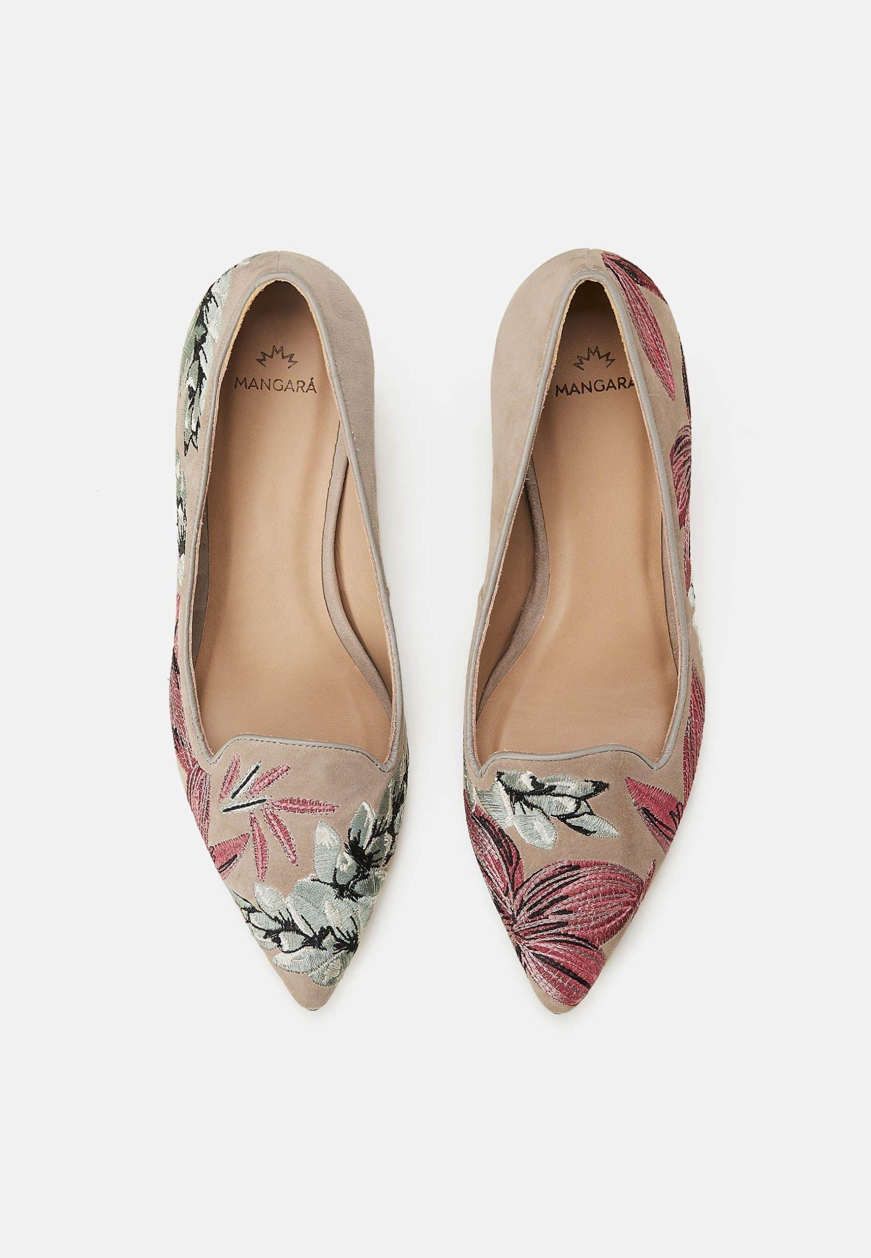 Pair of floral pointed-toe flats on a light gray background