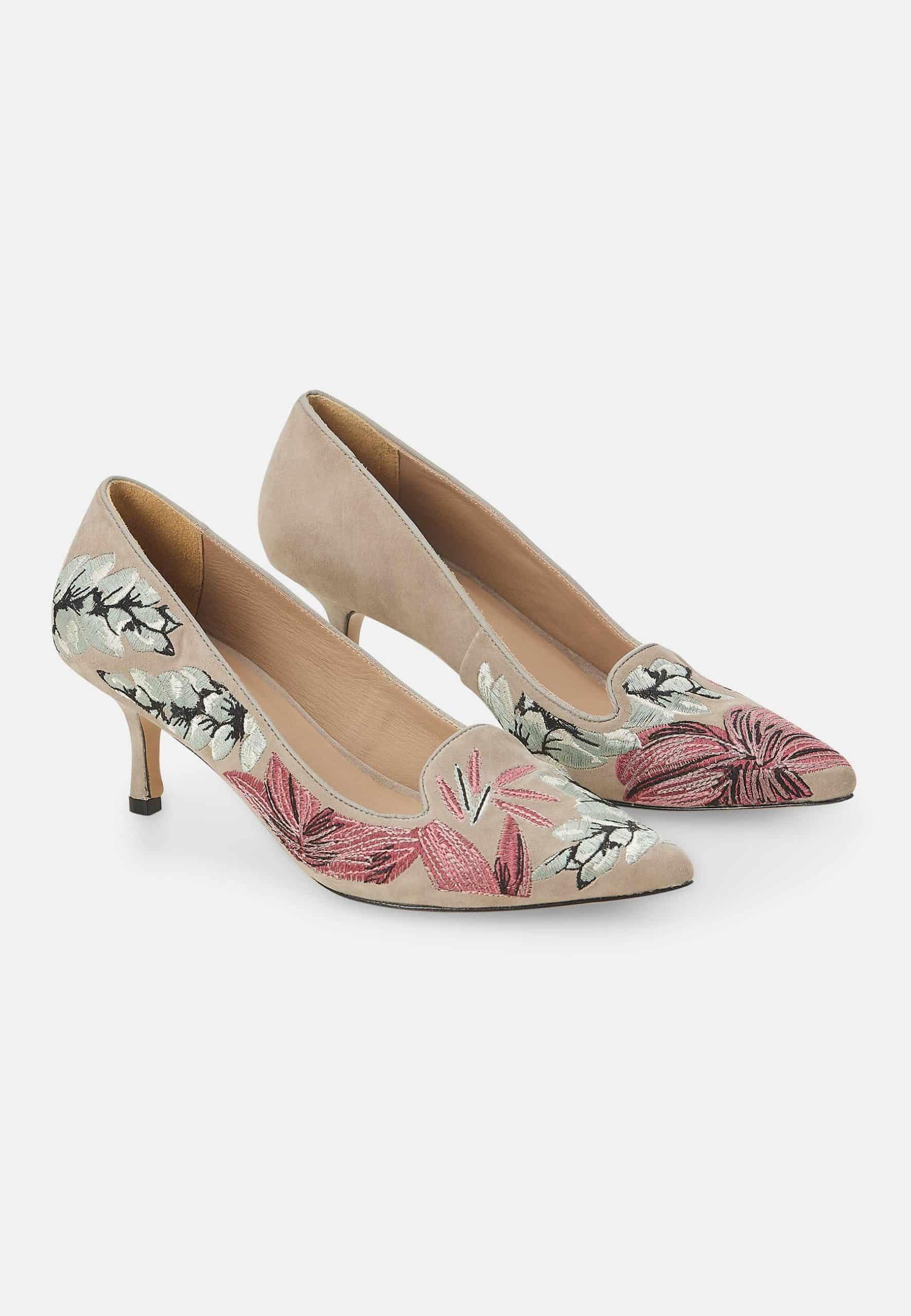 Pair of high-heeled shoes with floral design on a white background