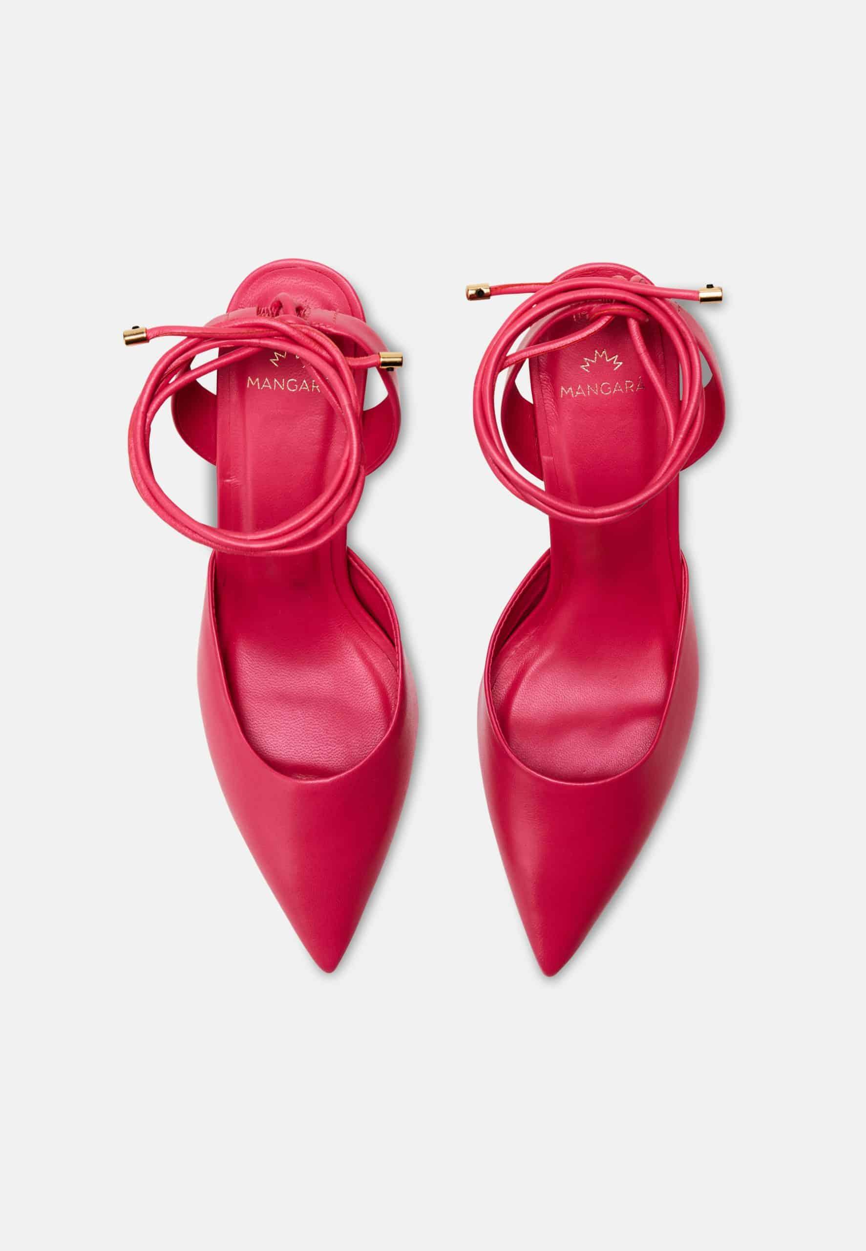 Pair of bright pink high-heeled shoes with pointed toes on a white background