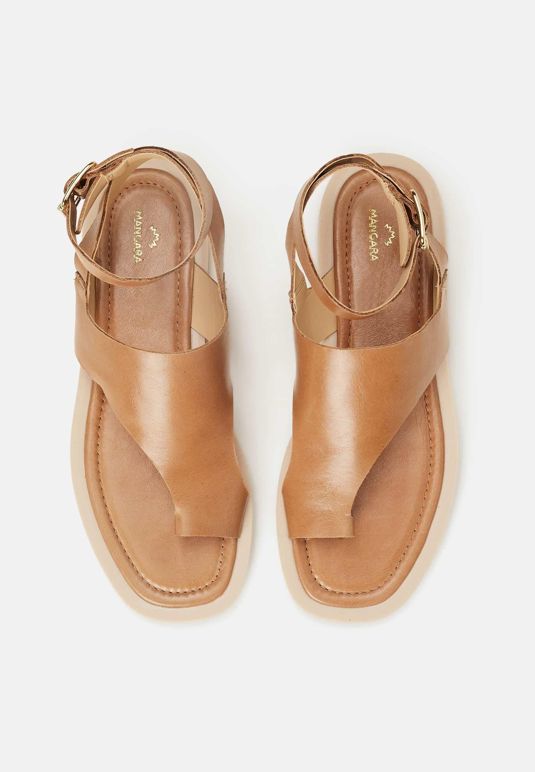 Pair of tan sandals on a white background