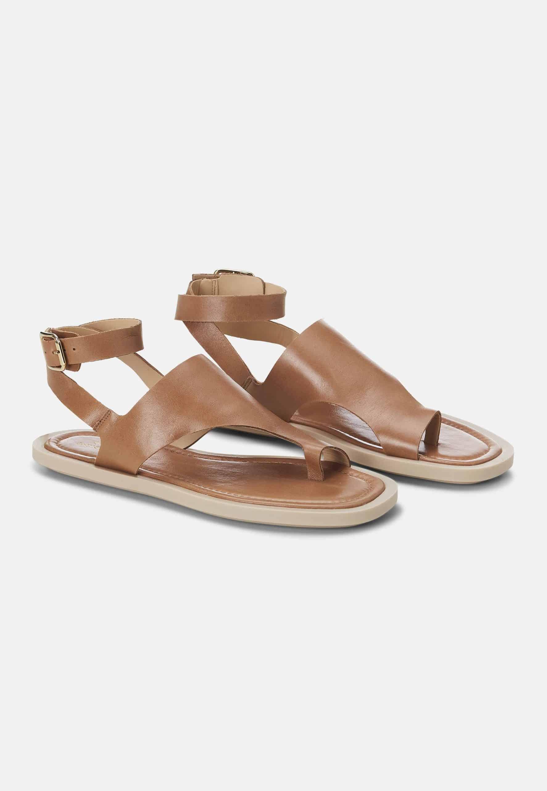 Pair of brown sandals on a light gray background