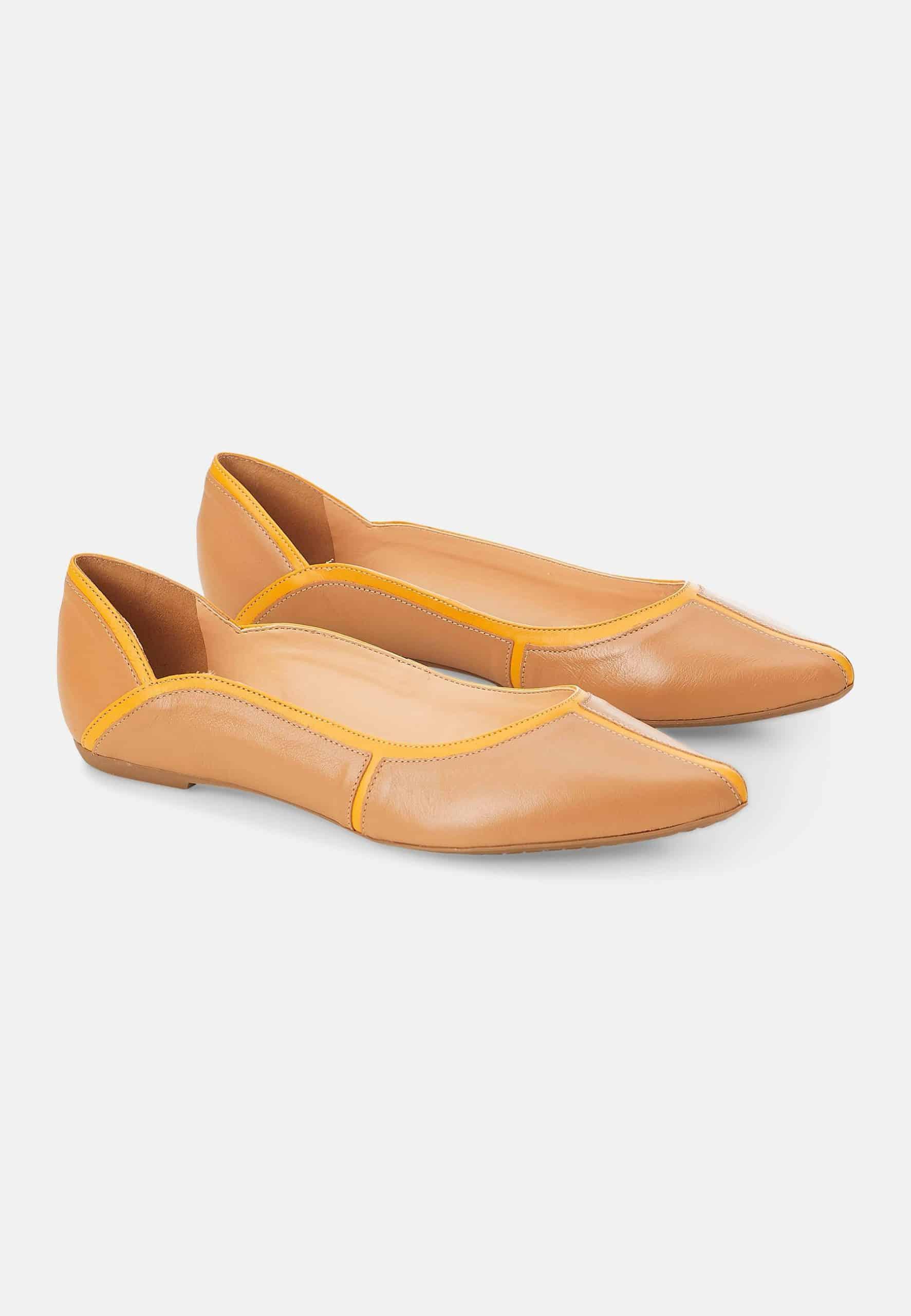 Pair of tan flats with yellow accents on a white background