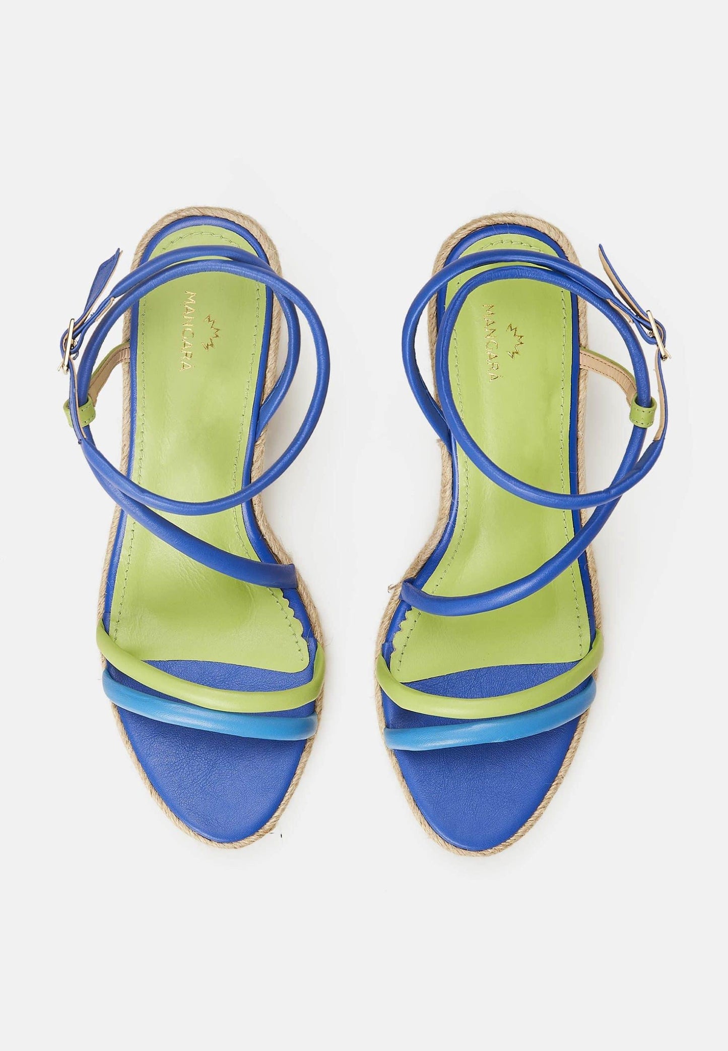 Pair of green and blue strappy sandals on a white background