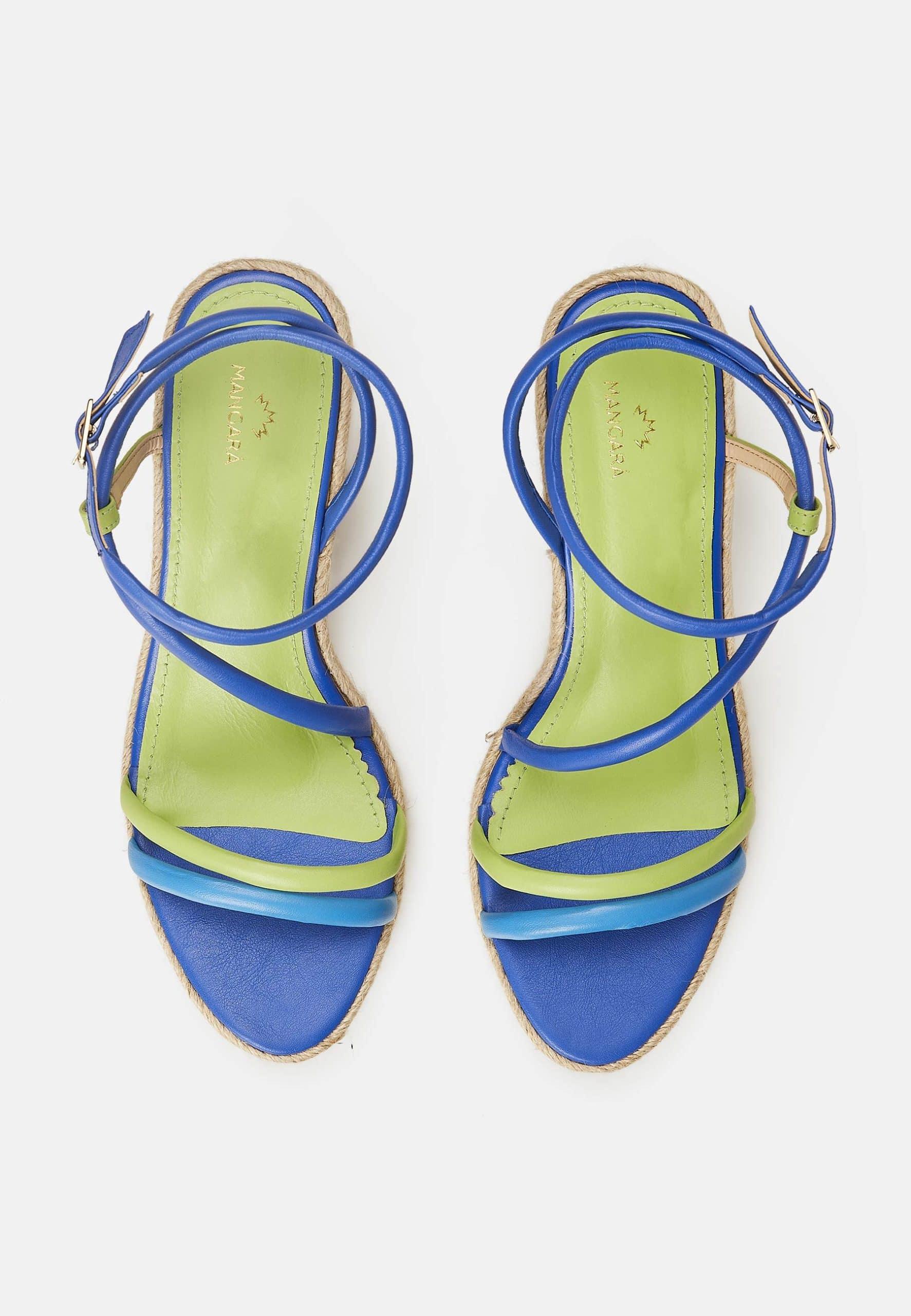 Pair of green and blue strappy sandals on a white background