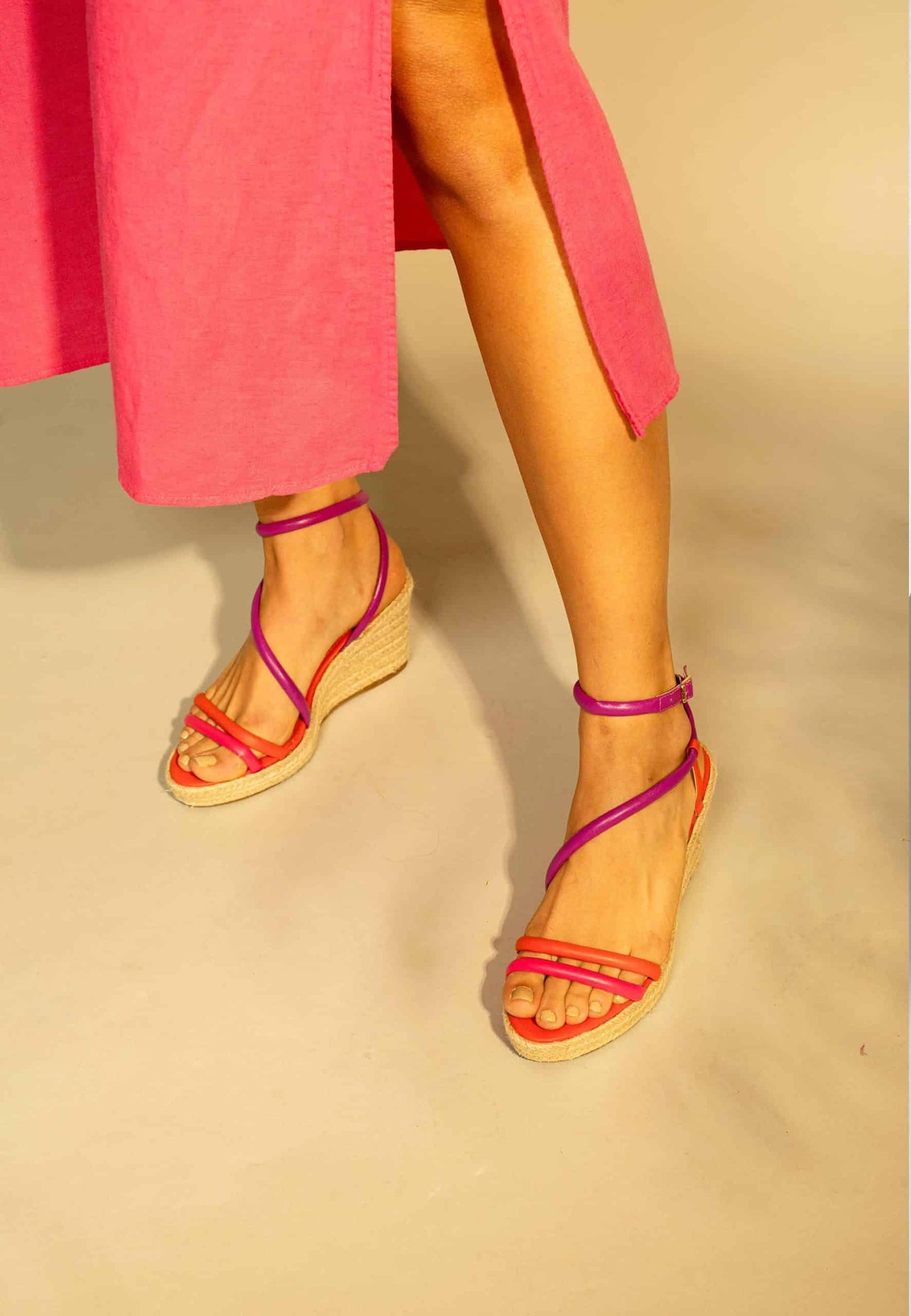 Person wearing pink sandals on a beige background