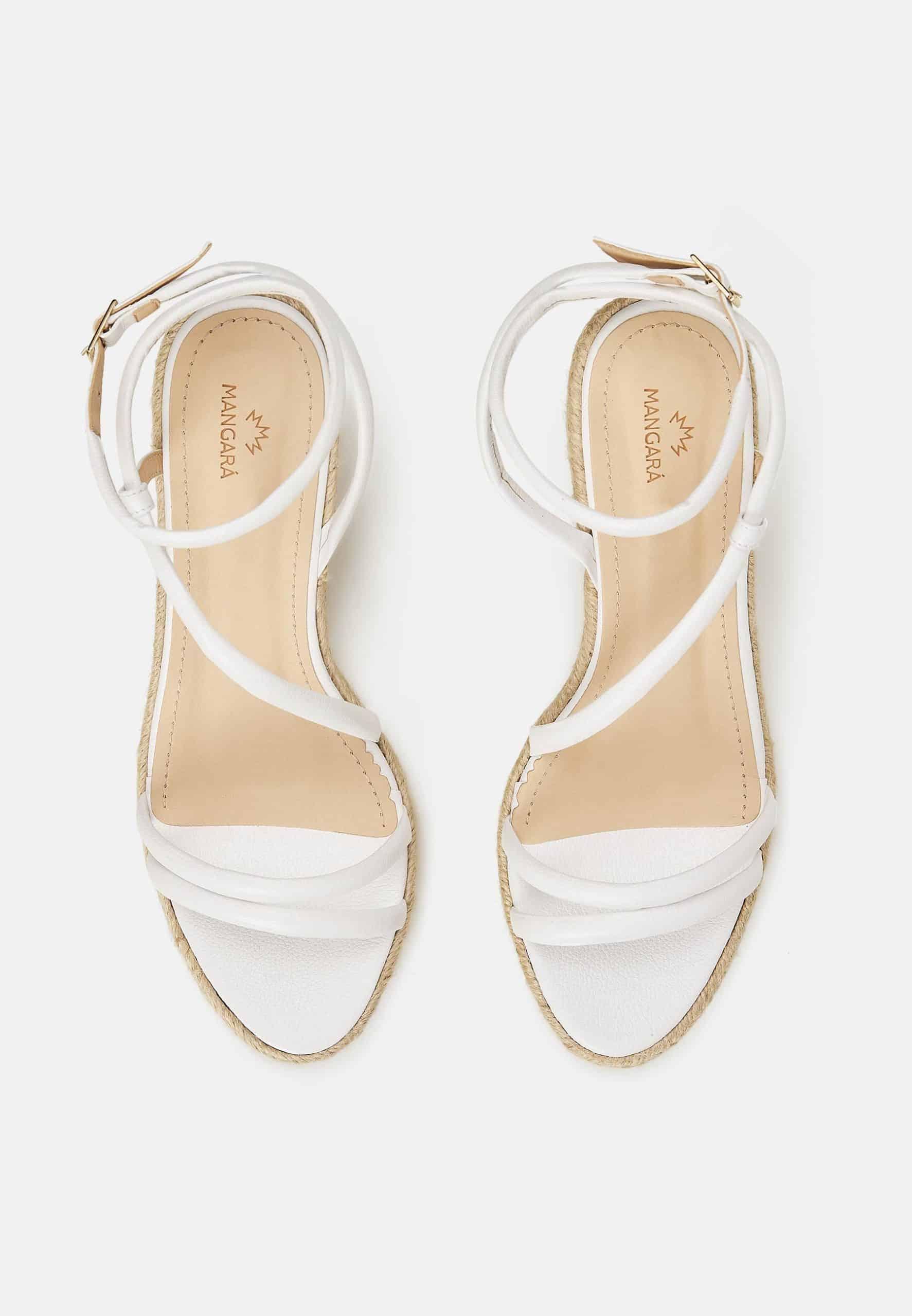 Pair of white sandals with thin straps on a white background