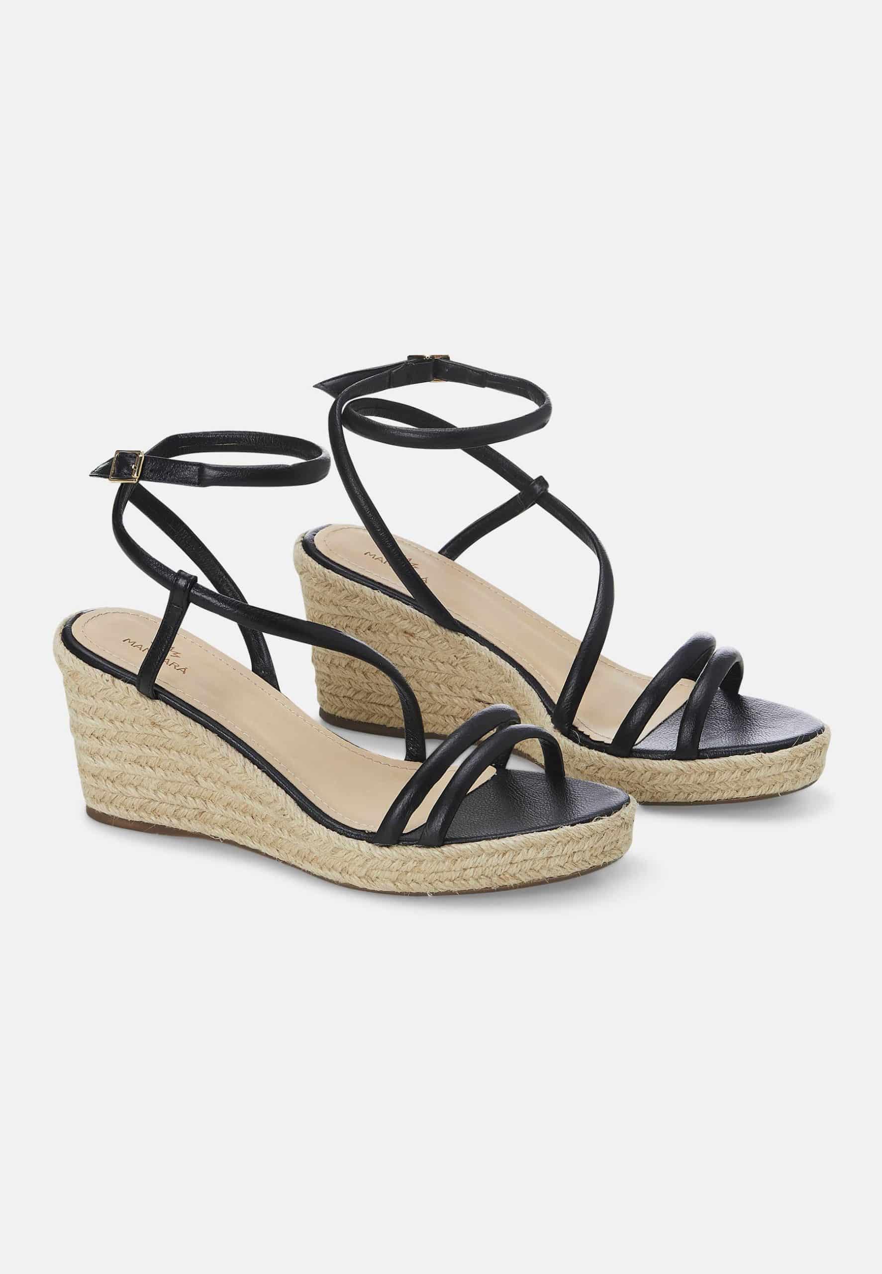 Black wedge sandals with espadrille sole on a white background