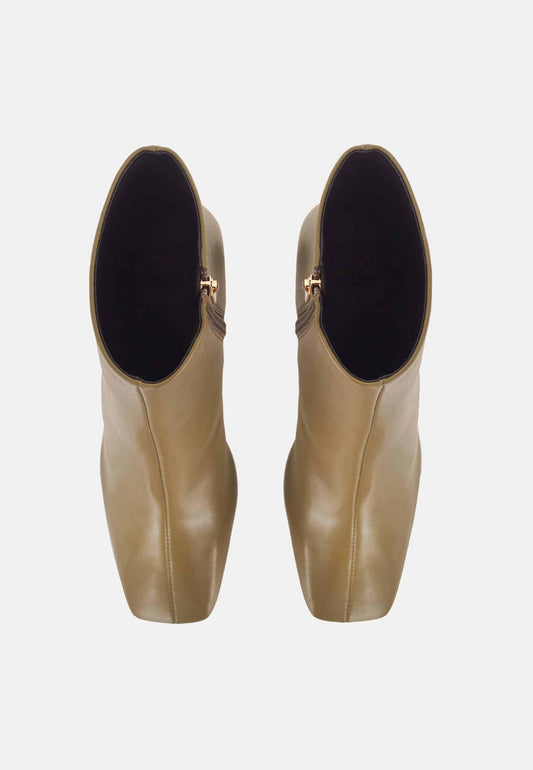 Pair of beige ankle boots with black soles on a white background