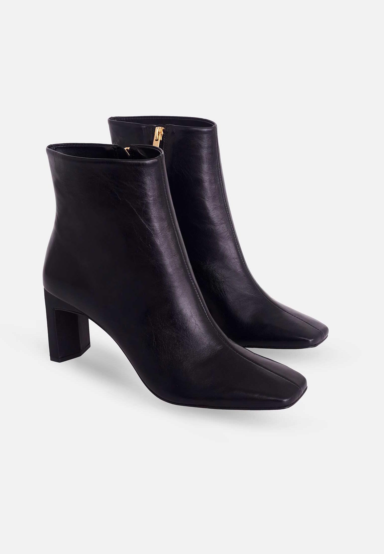 Black ankle boots with a block heel on a white background