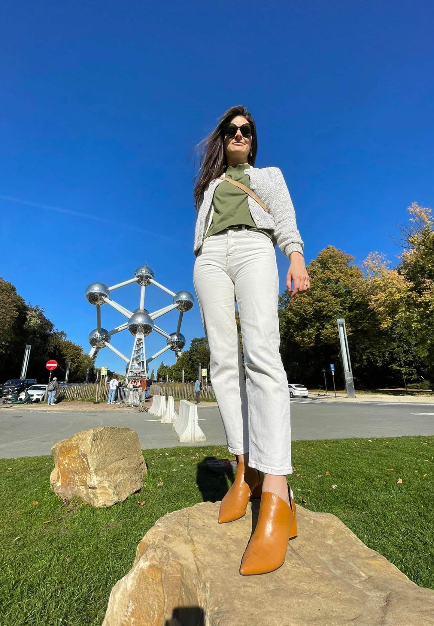 Woman standing on a rock with a large metal sculpture in the background