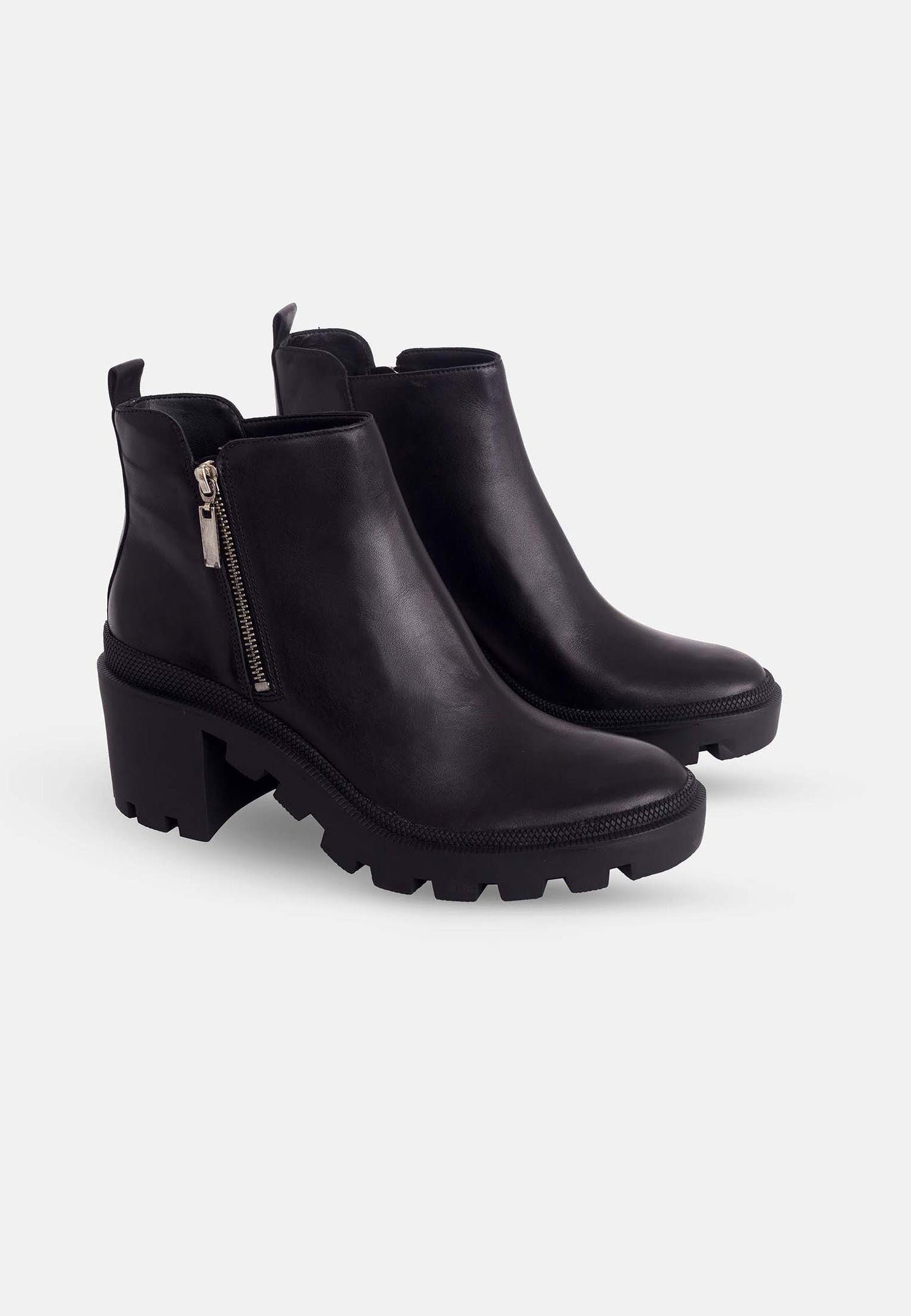 Black ankle boots with chunky soles on a white background