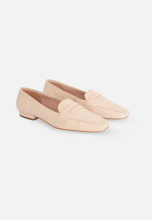 Pair of beige loafers on a white background