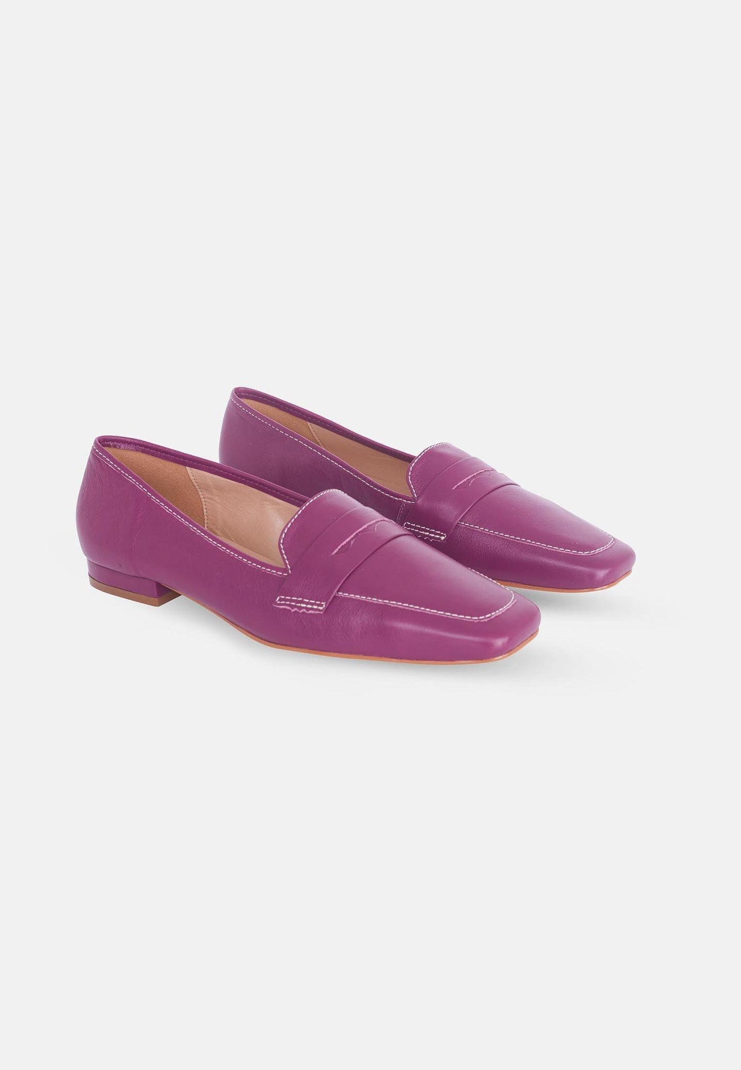 Pair of purple loafers on a white background
