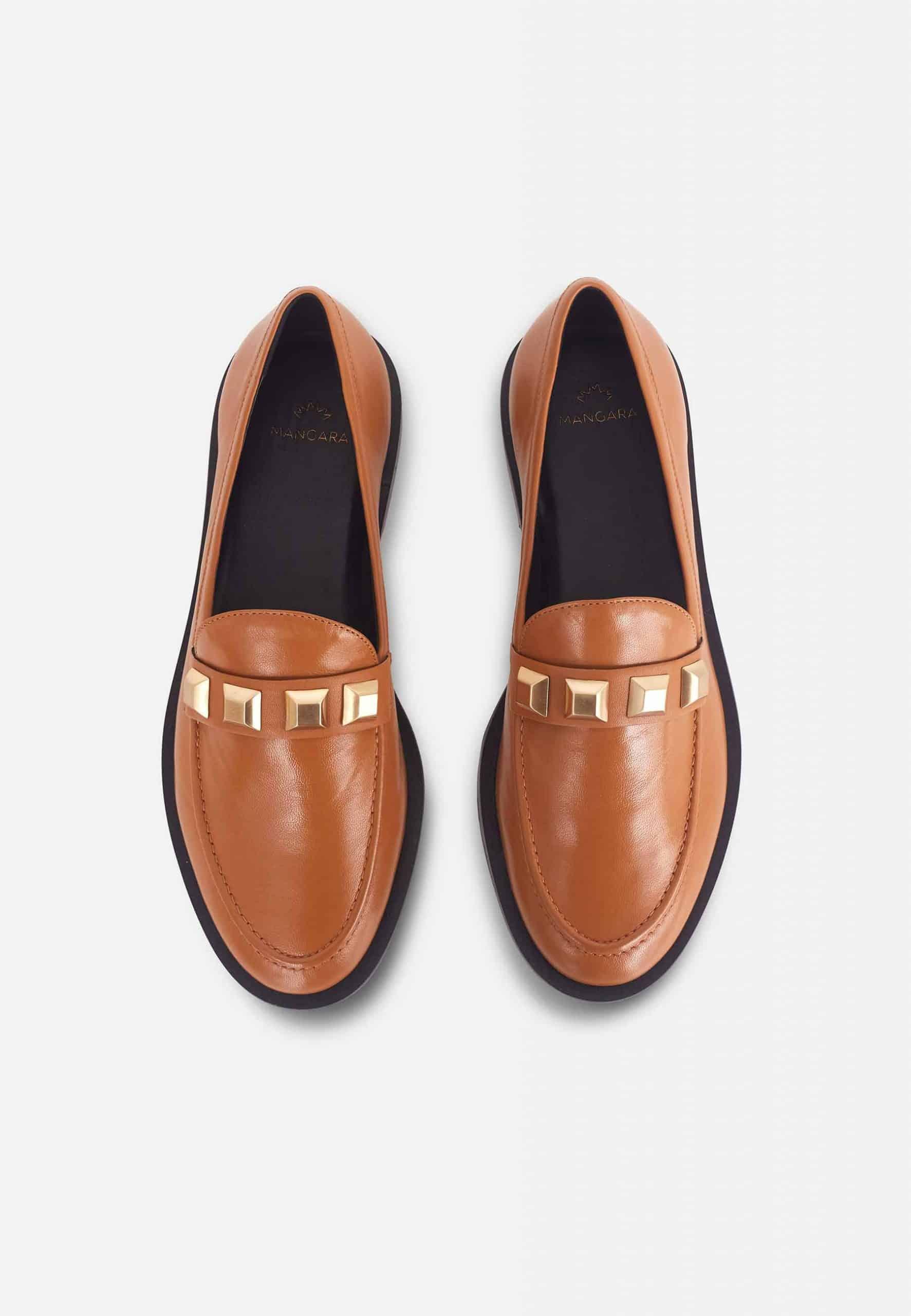 Pair of brown loafers with gold accents on a light gray background