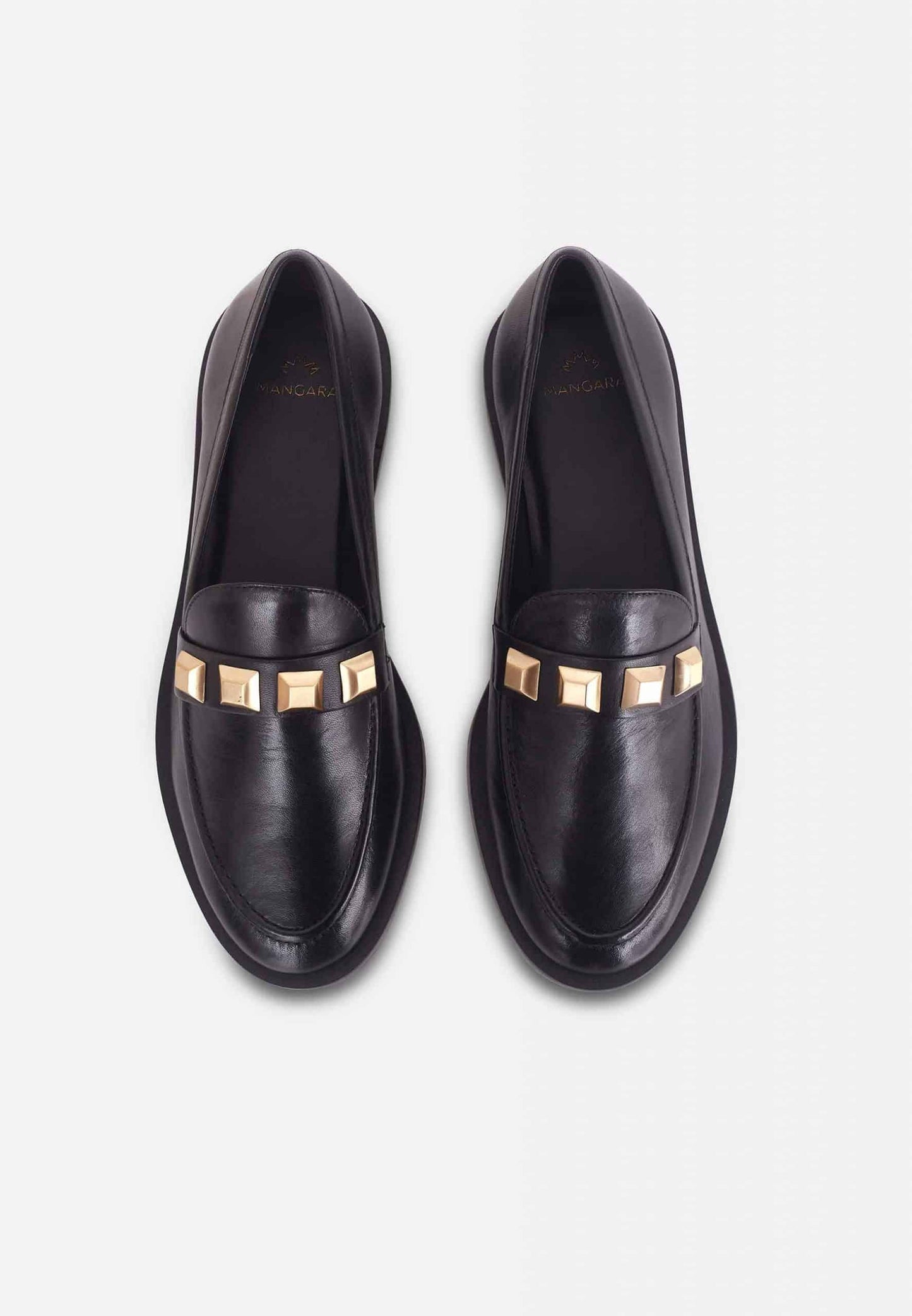Pair of black loafers with gold accents on a light gray background