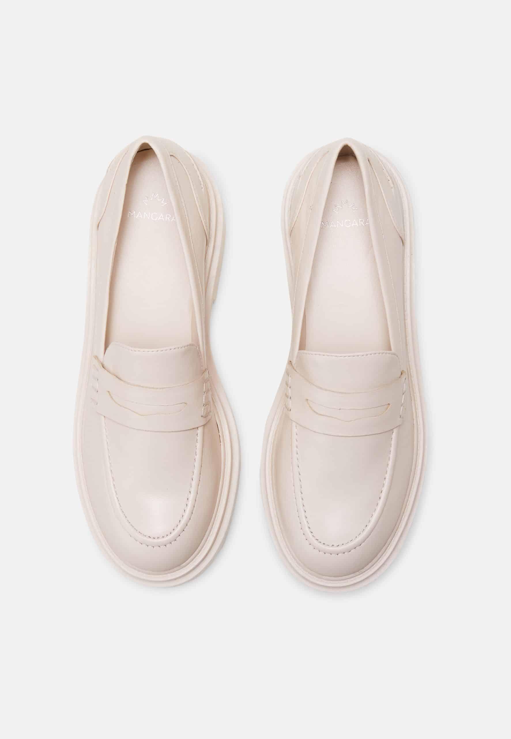Pair of beige loafers on a white background