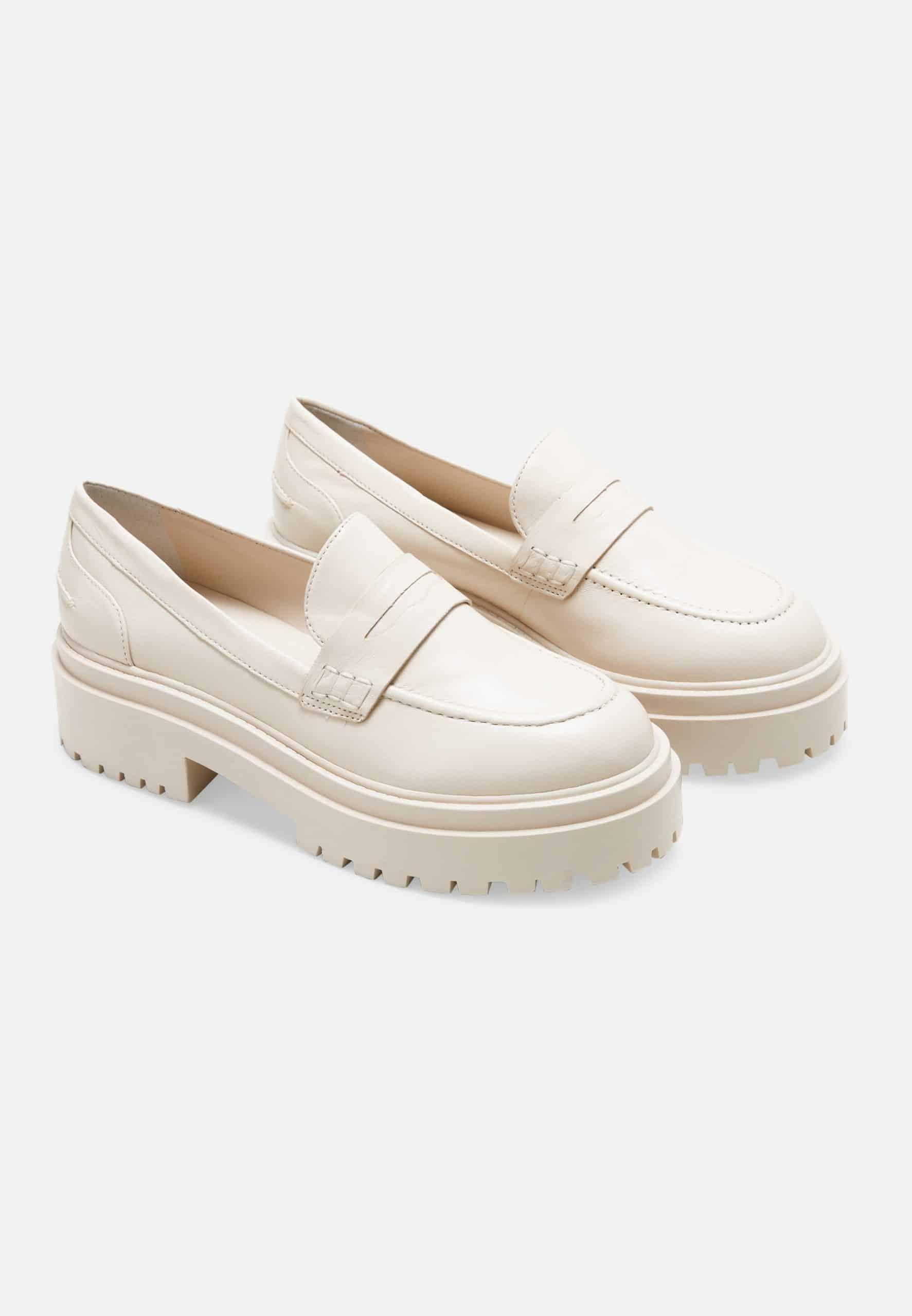 Pair of cream-colored loafers on a white background