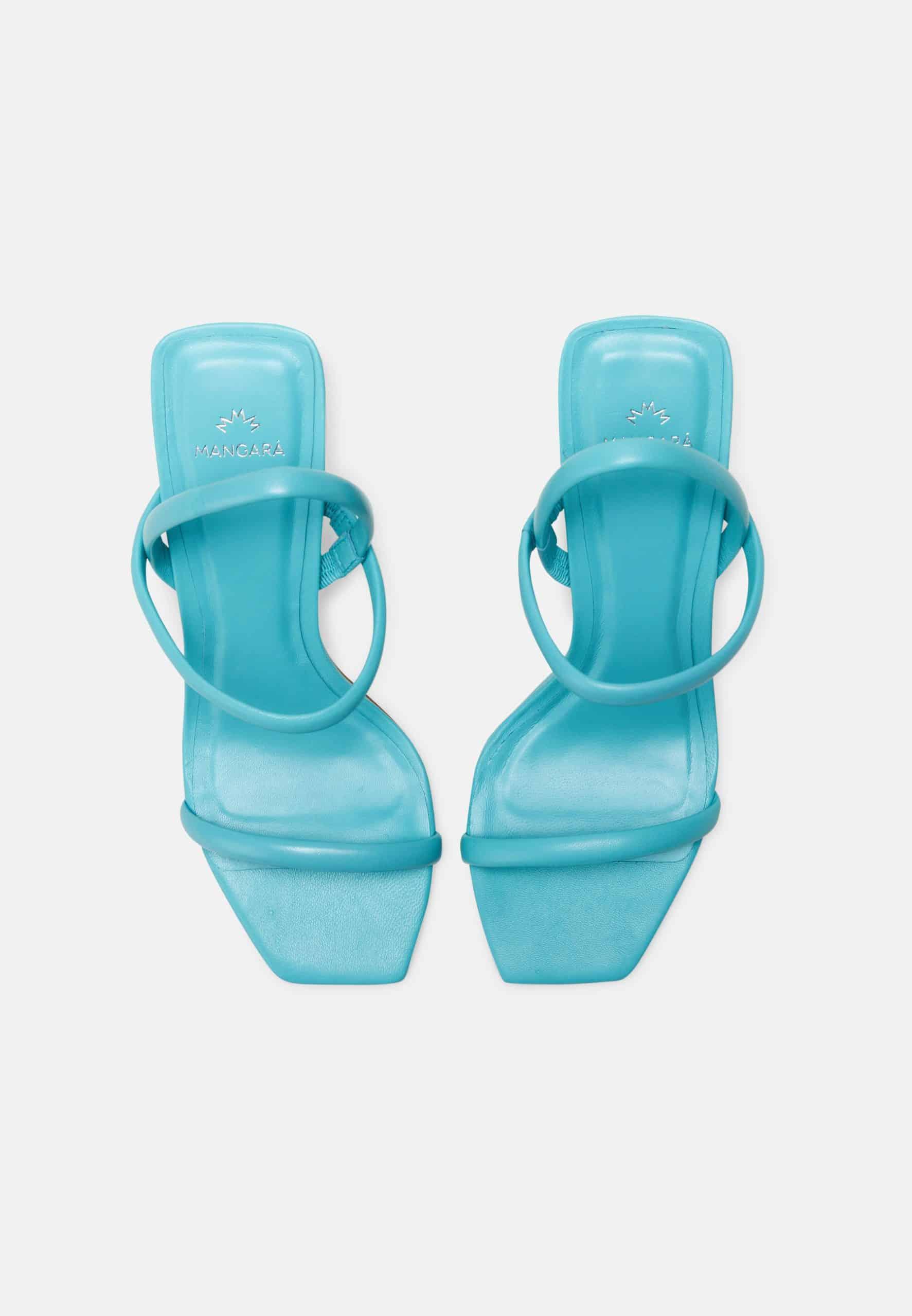 Pair of turquoise high-heeled sandals on a white background