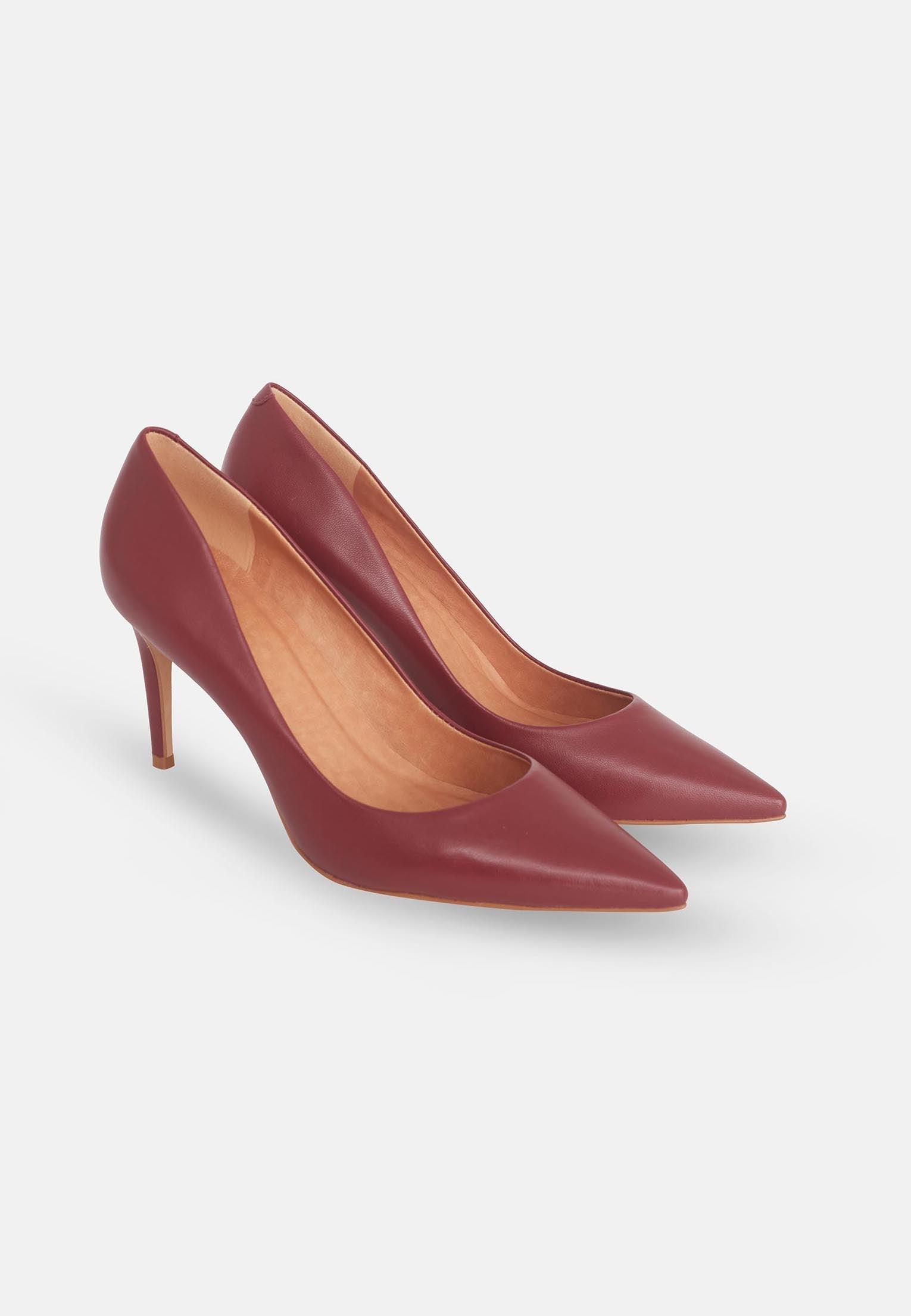 Pair of maroon high-heeled shoes on a light gray background