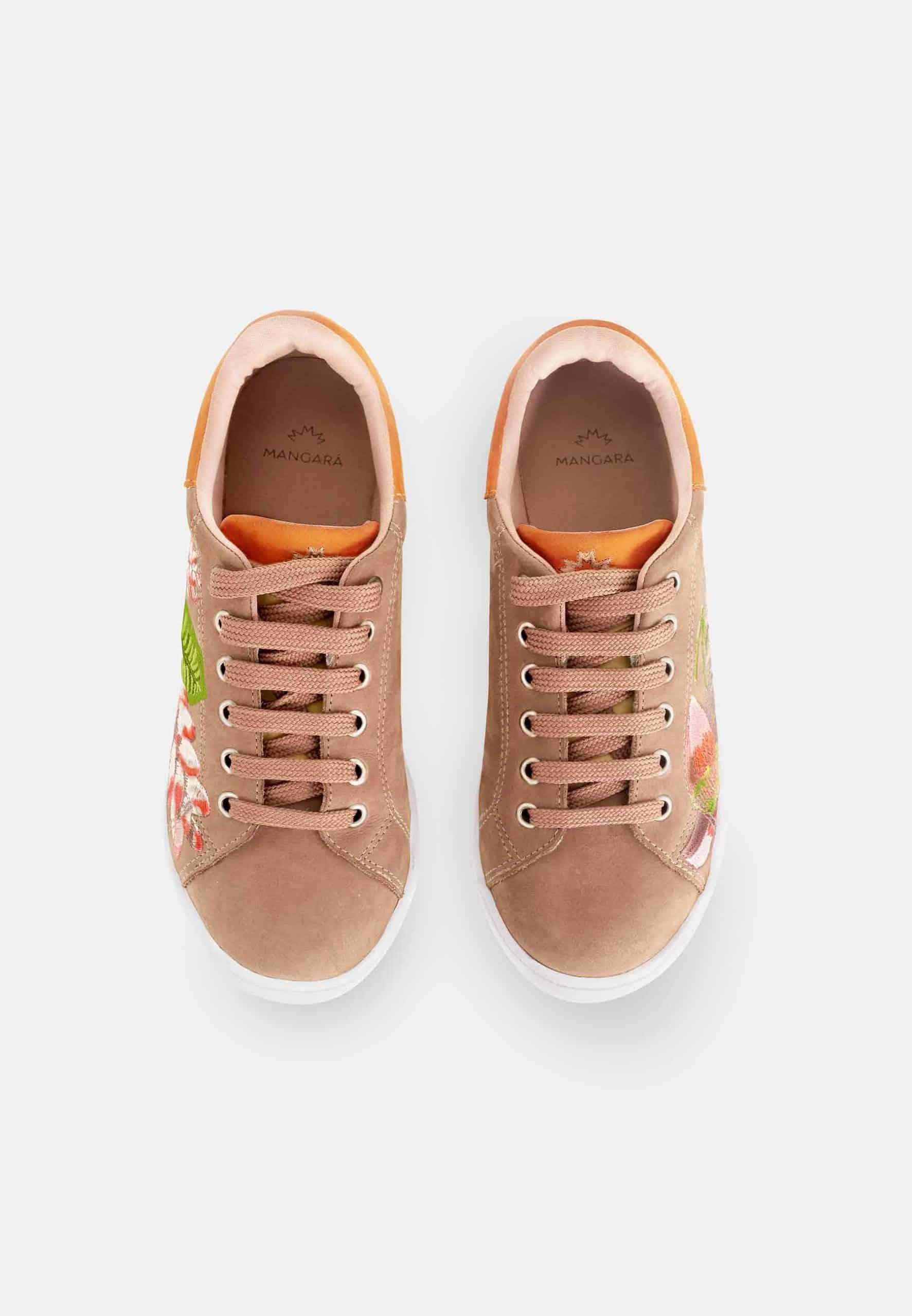 Pair of tan sneakers with floral patterns on a white background