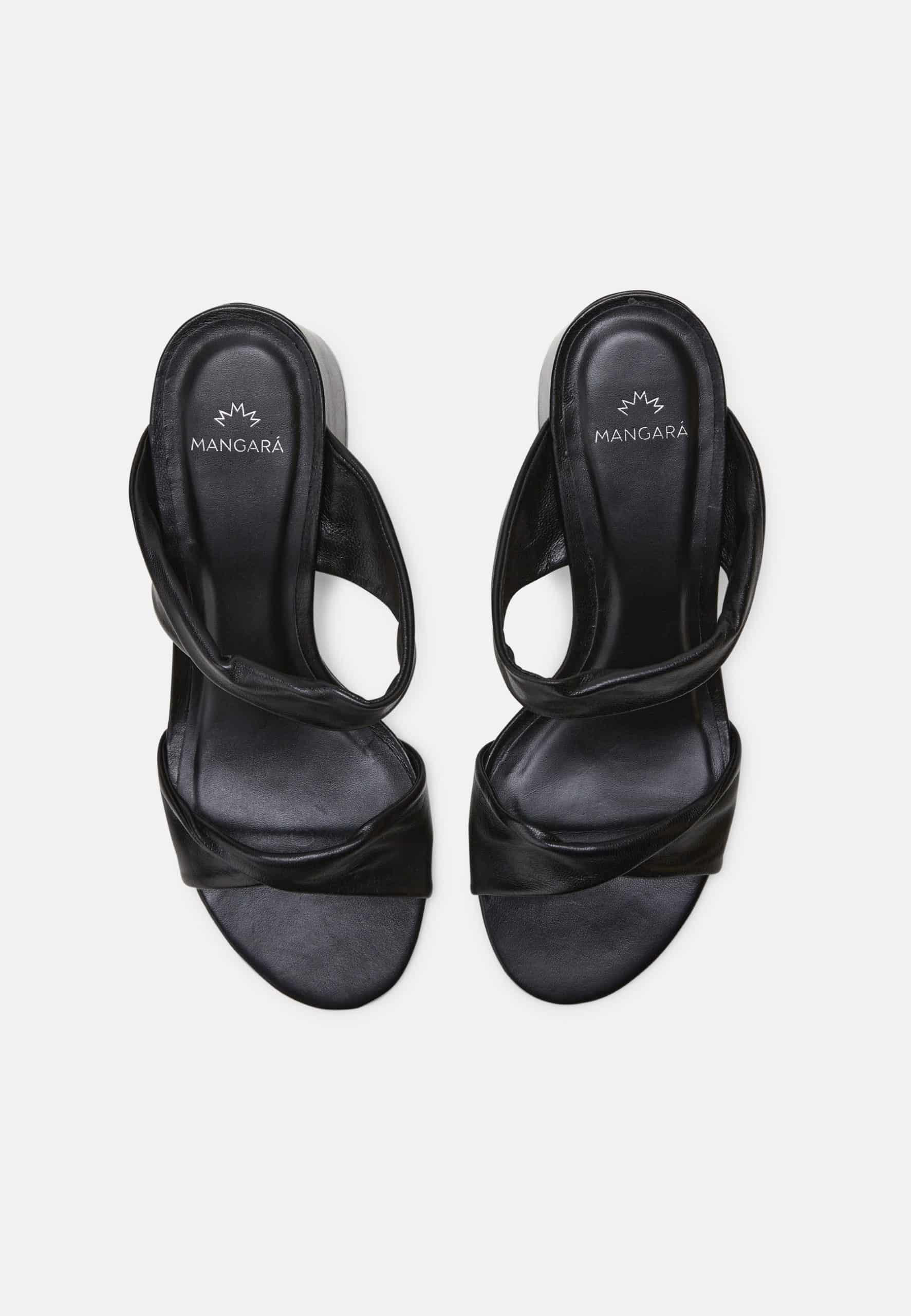 Black high-heeled sandals with criss-cross straps on a white background