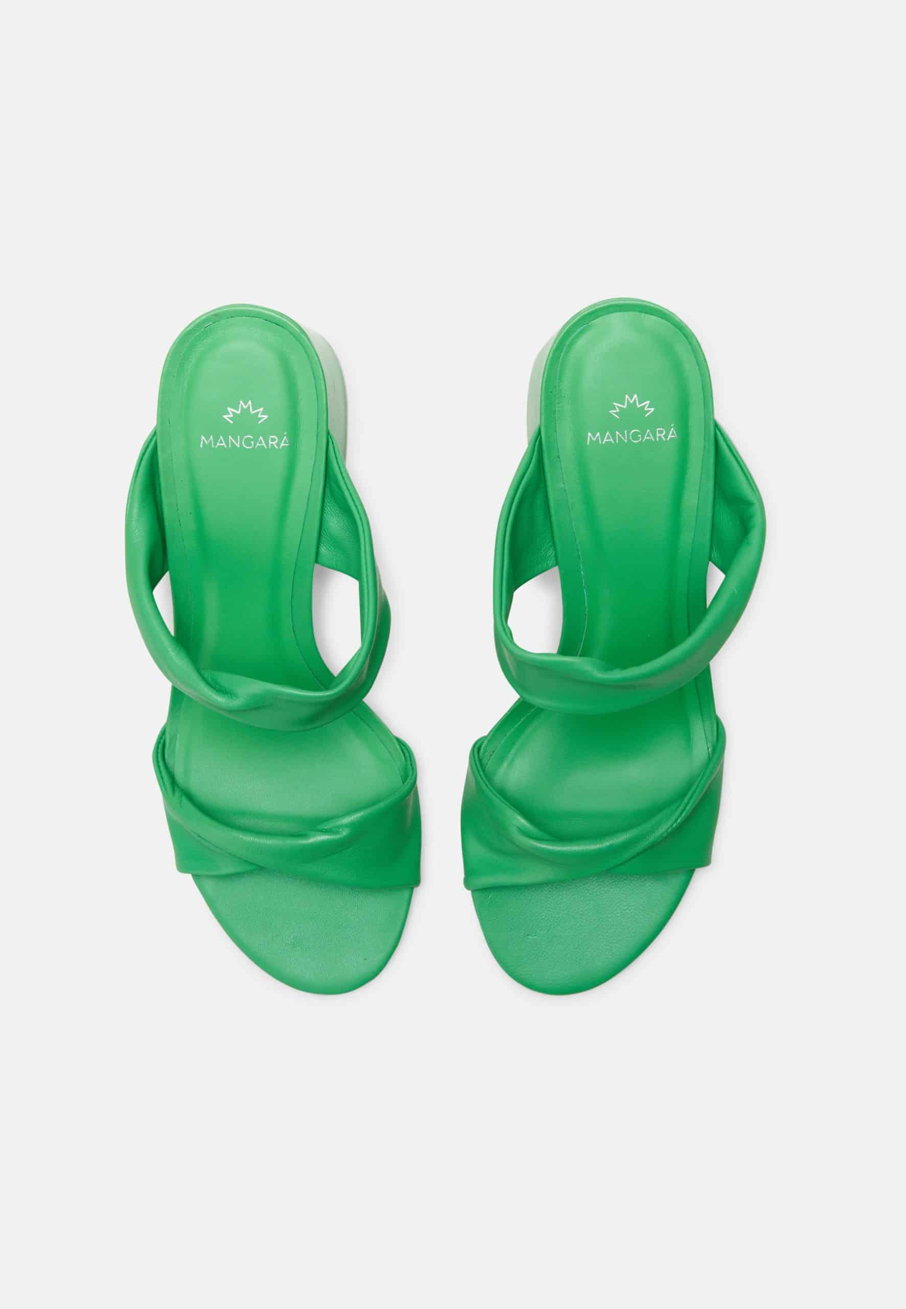 Green high-heeled sandals on a light gray background