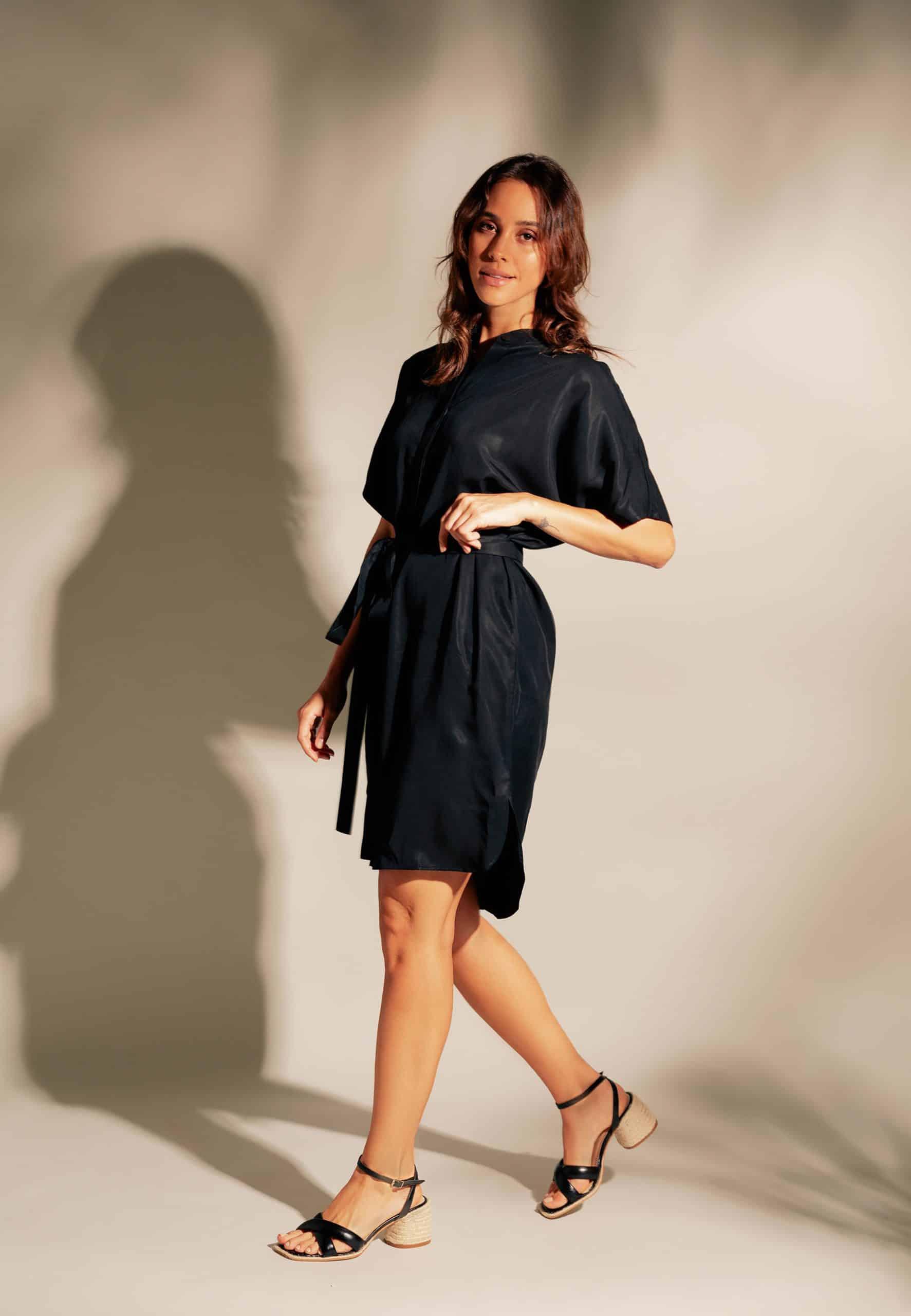 Woman wearing a black dress against a neutral background