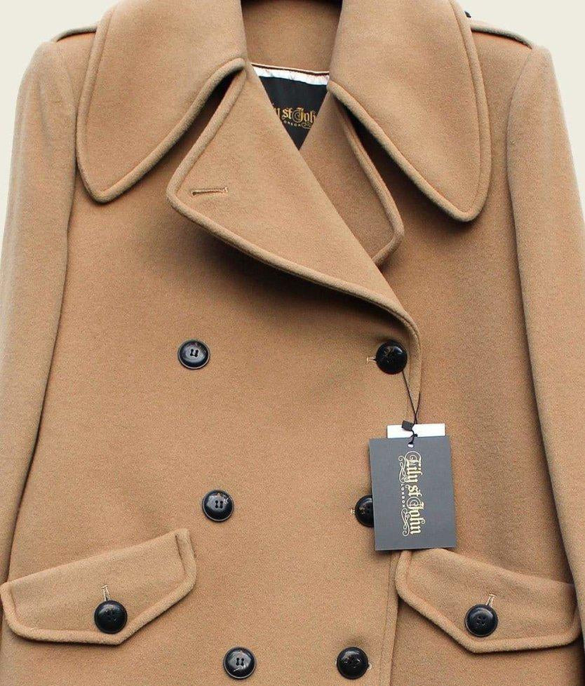 Close-up of a tan coat with black buttons and a visible brand tag