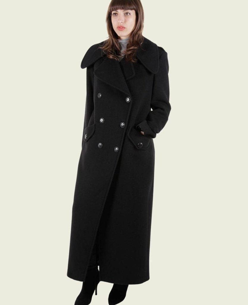 Woman wearing a long black coat on a white background