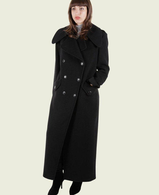 Woman wearing a long black coat on a white background