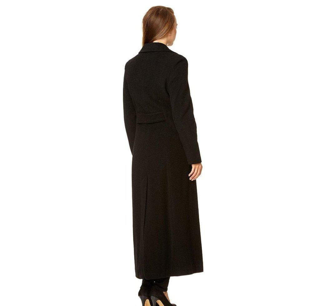 Woman wearing a long black coat on a white background