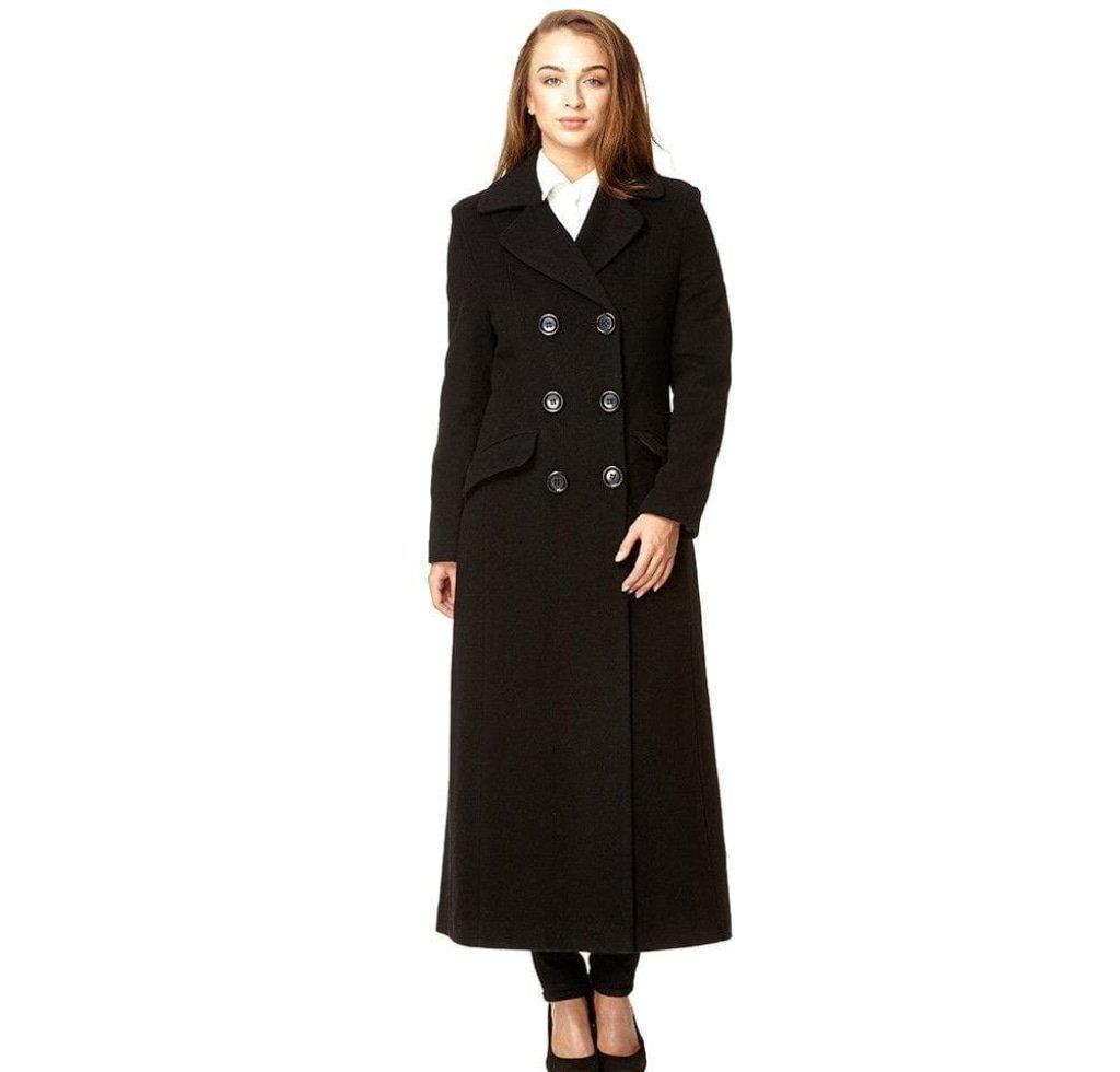 Woman wearing a long black coat with silver buttons on a white background
