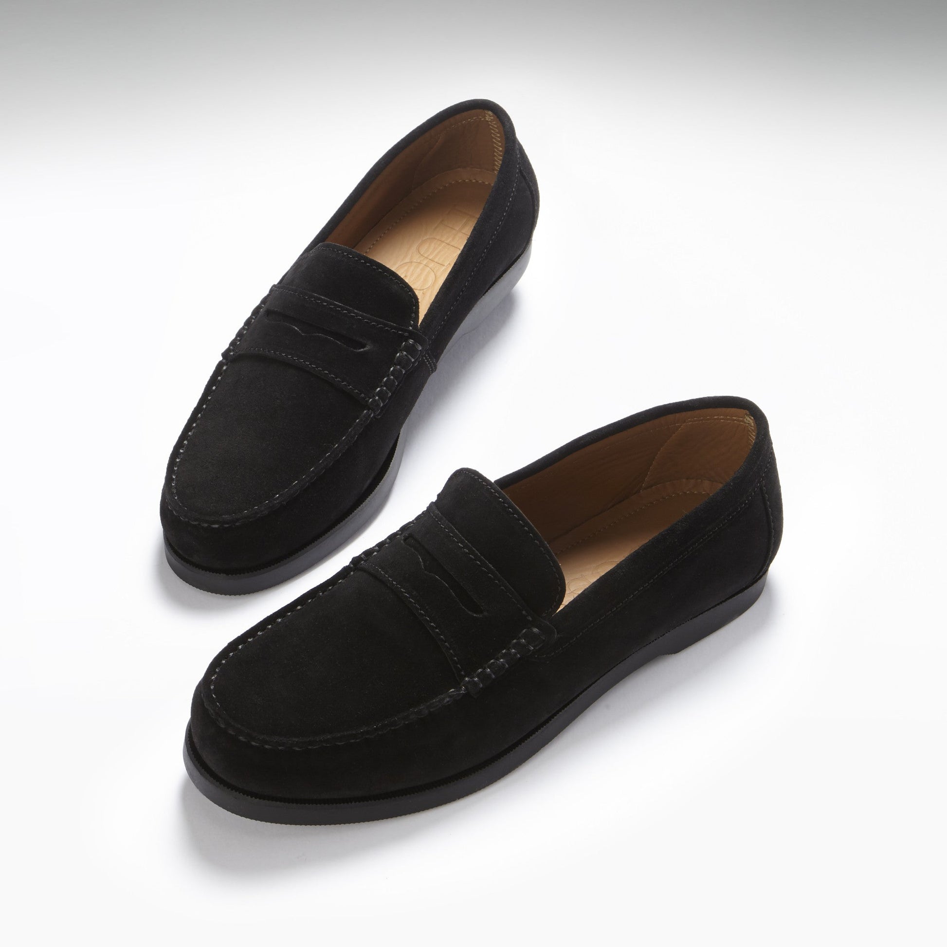 Pair of black loafers on a white background