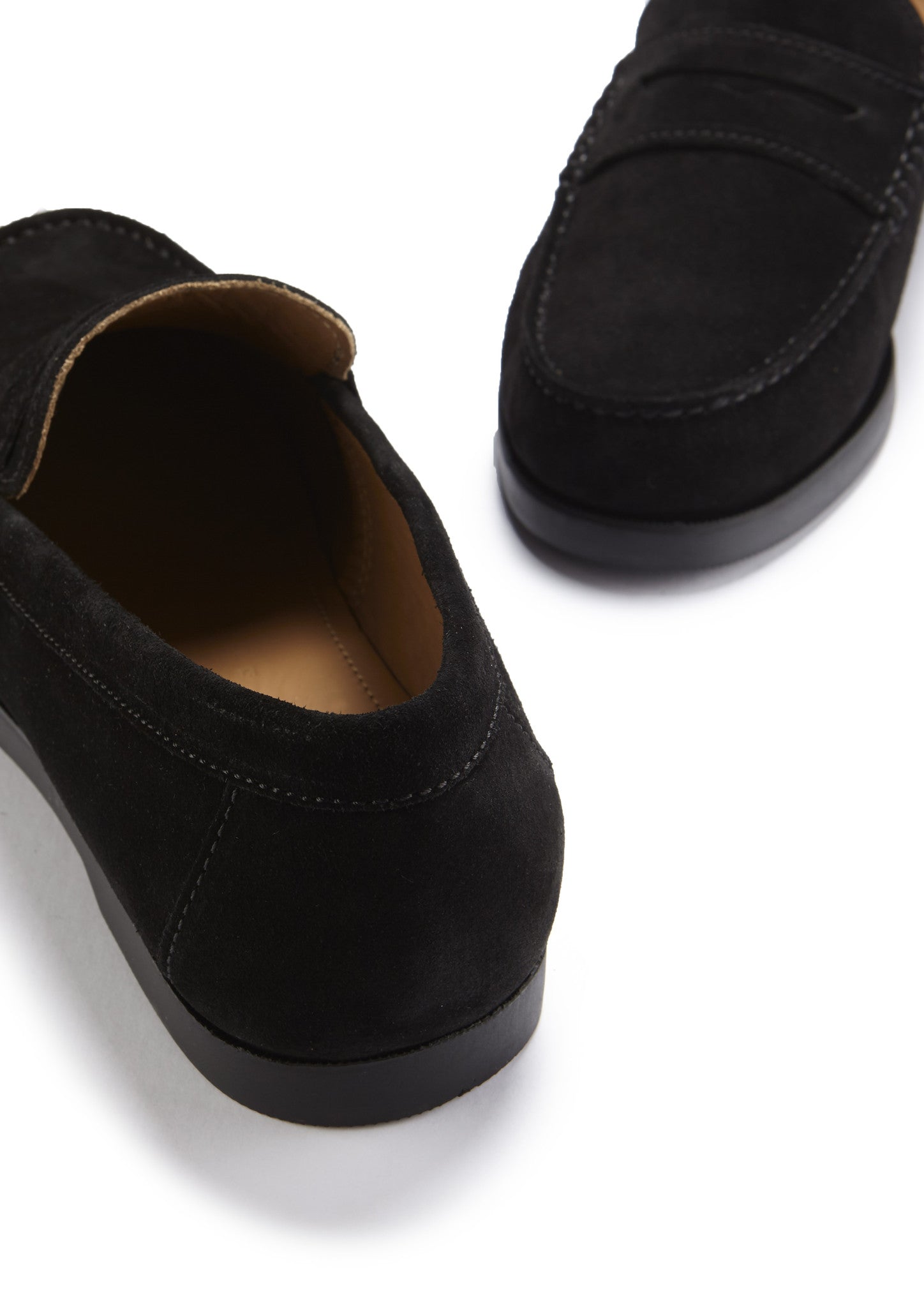 Black suede loafers on a white background