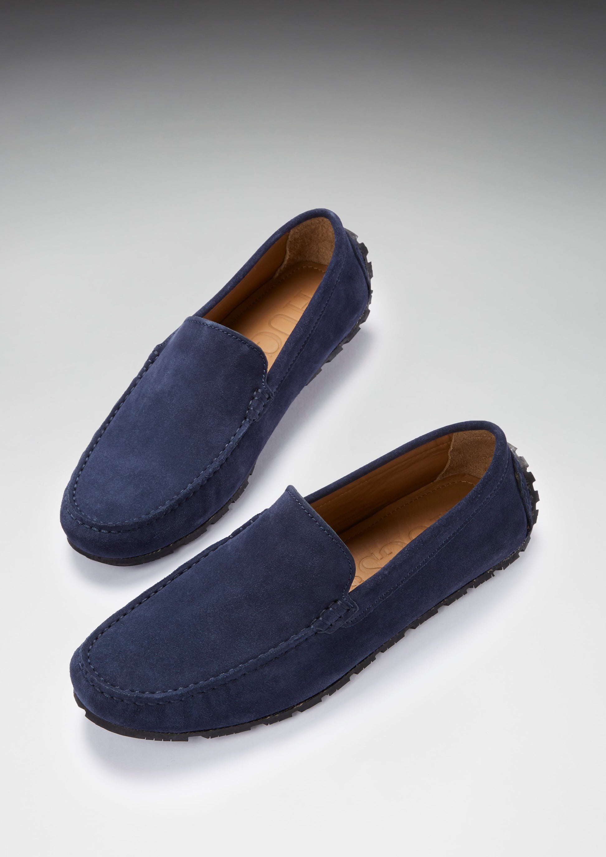 Pair of navy blue loafers on a light gray background