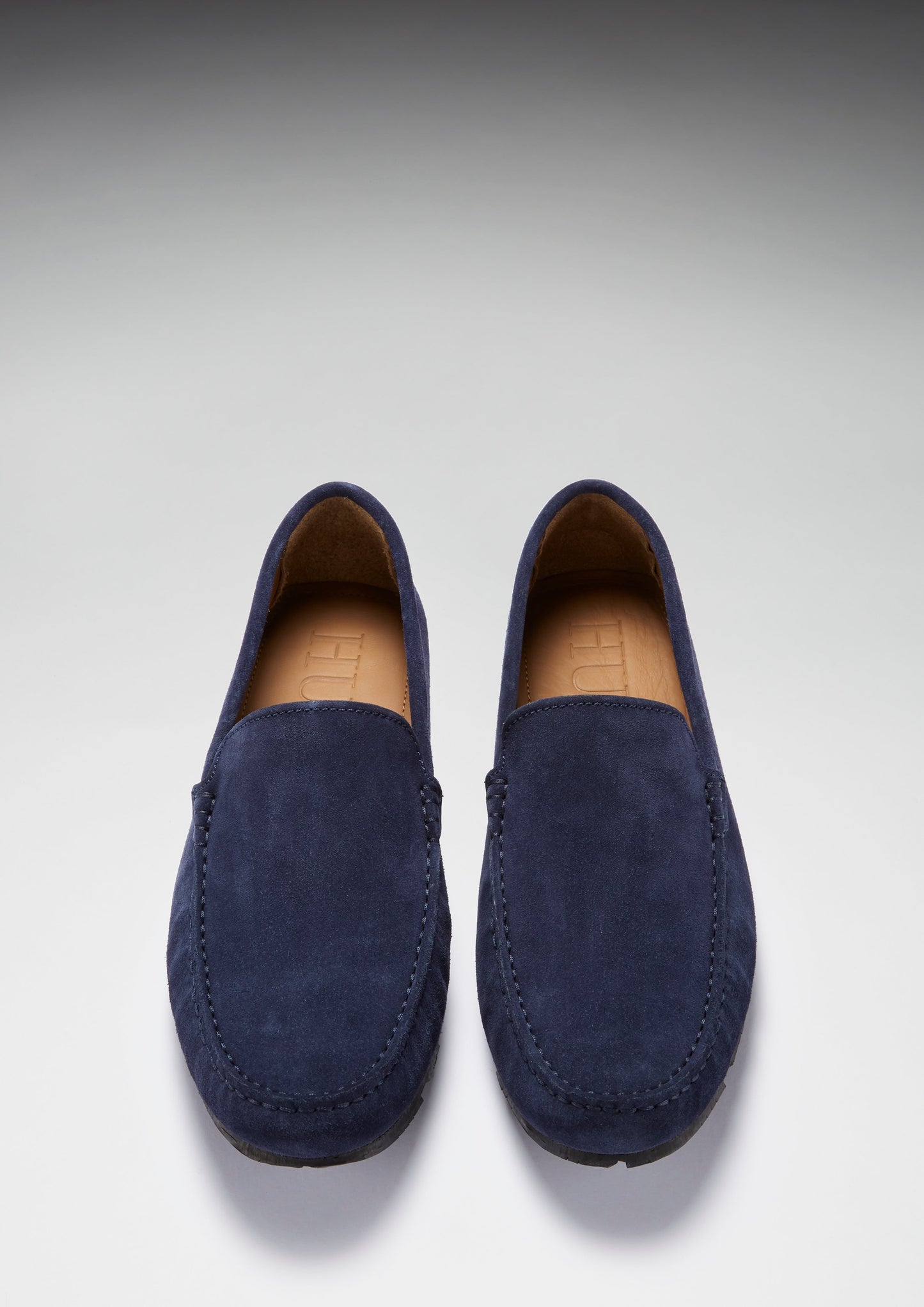 Pair of navy blue loafers on a light gray background