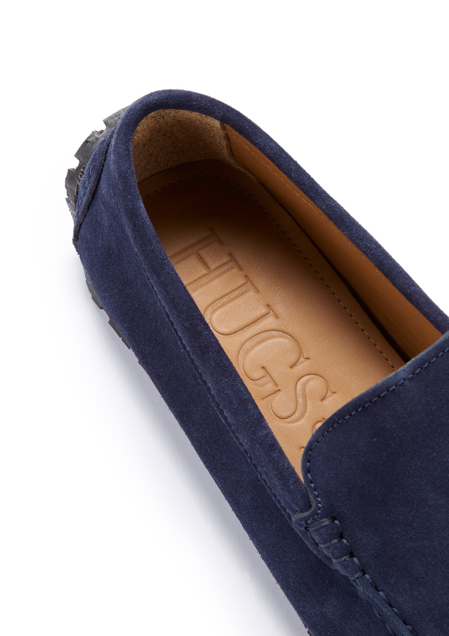 Navy blue suede loafer with tan interior on a white background