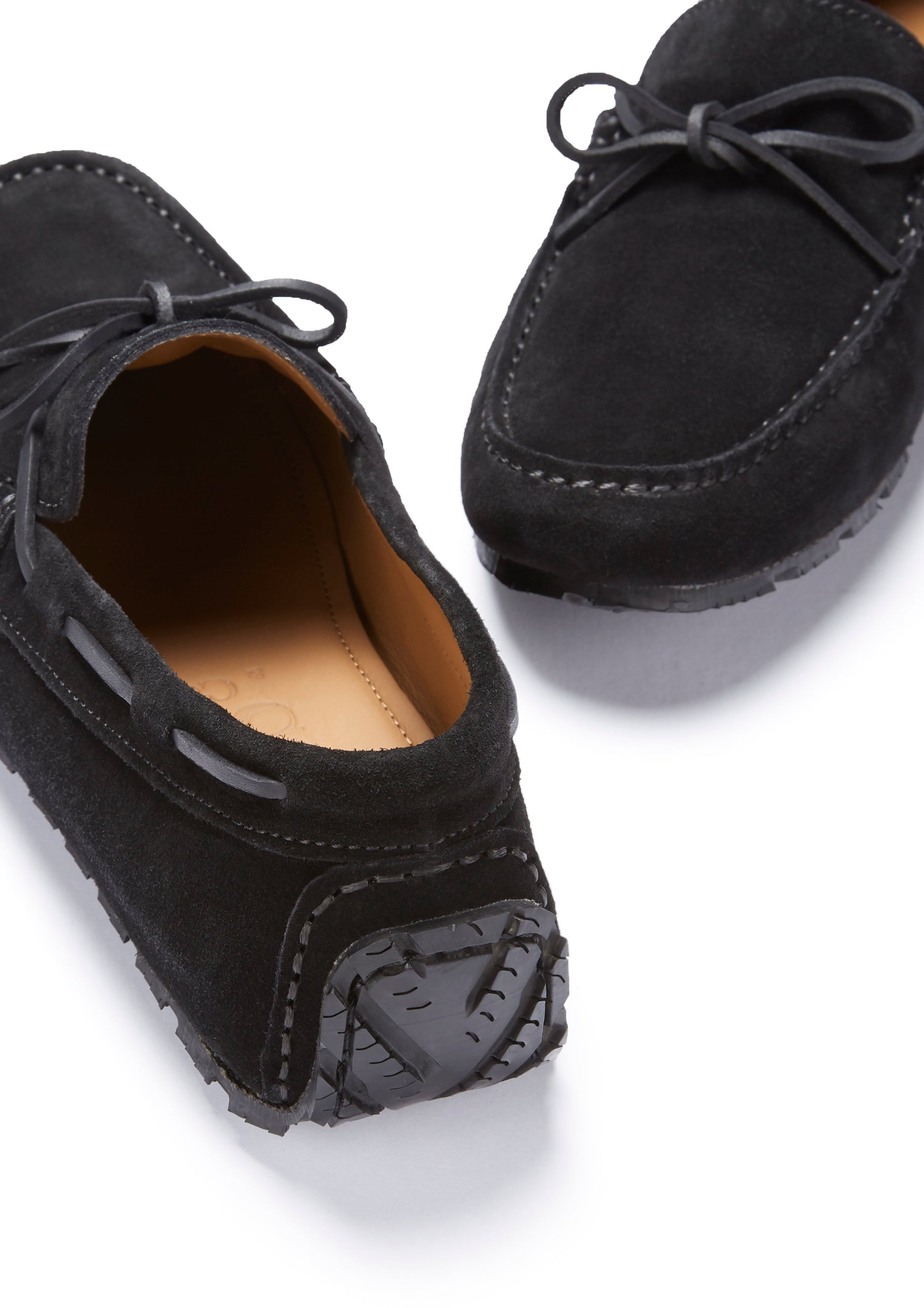 Black suede loafers on a white background