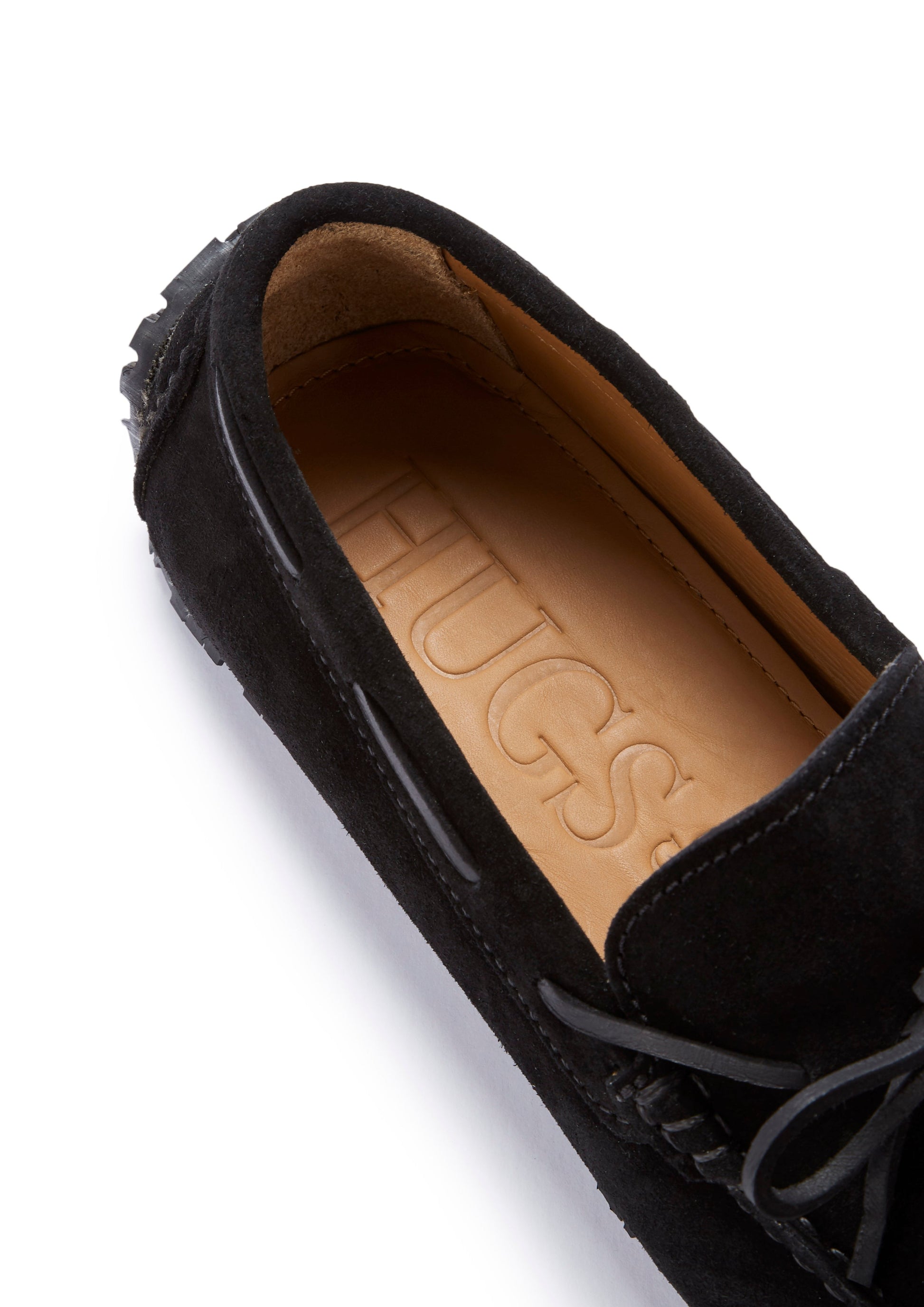 Black moccasin shoe with a tan insole on a white background