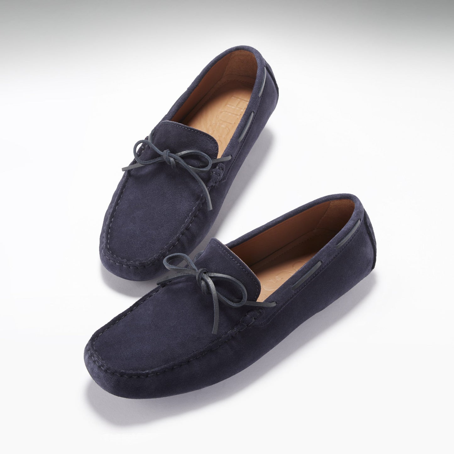 Pair of navy blue loafers on a light gray background
