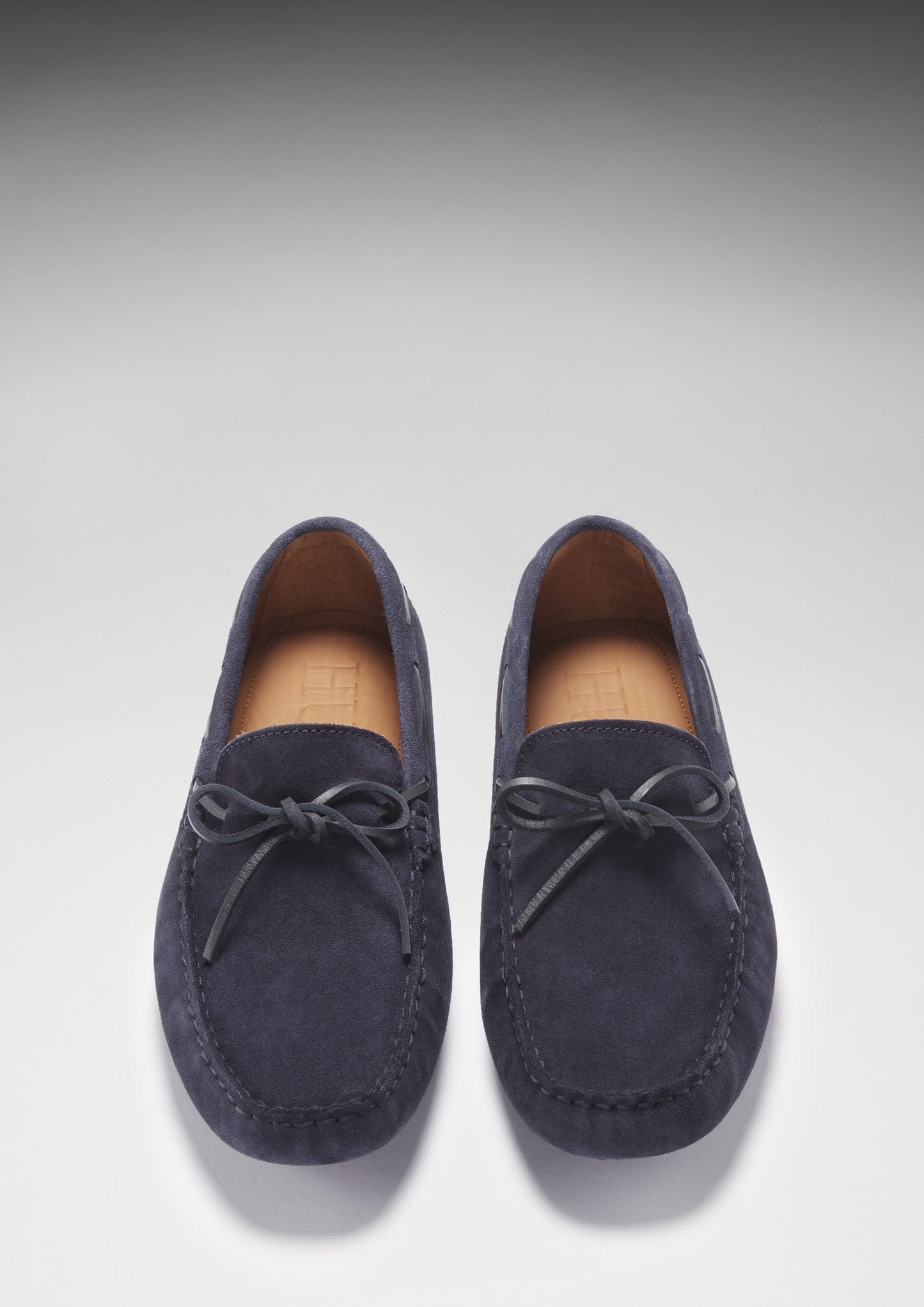 Pair of navy blue loafers on a light gray background