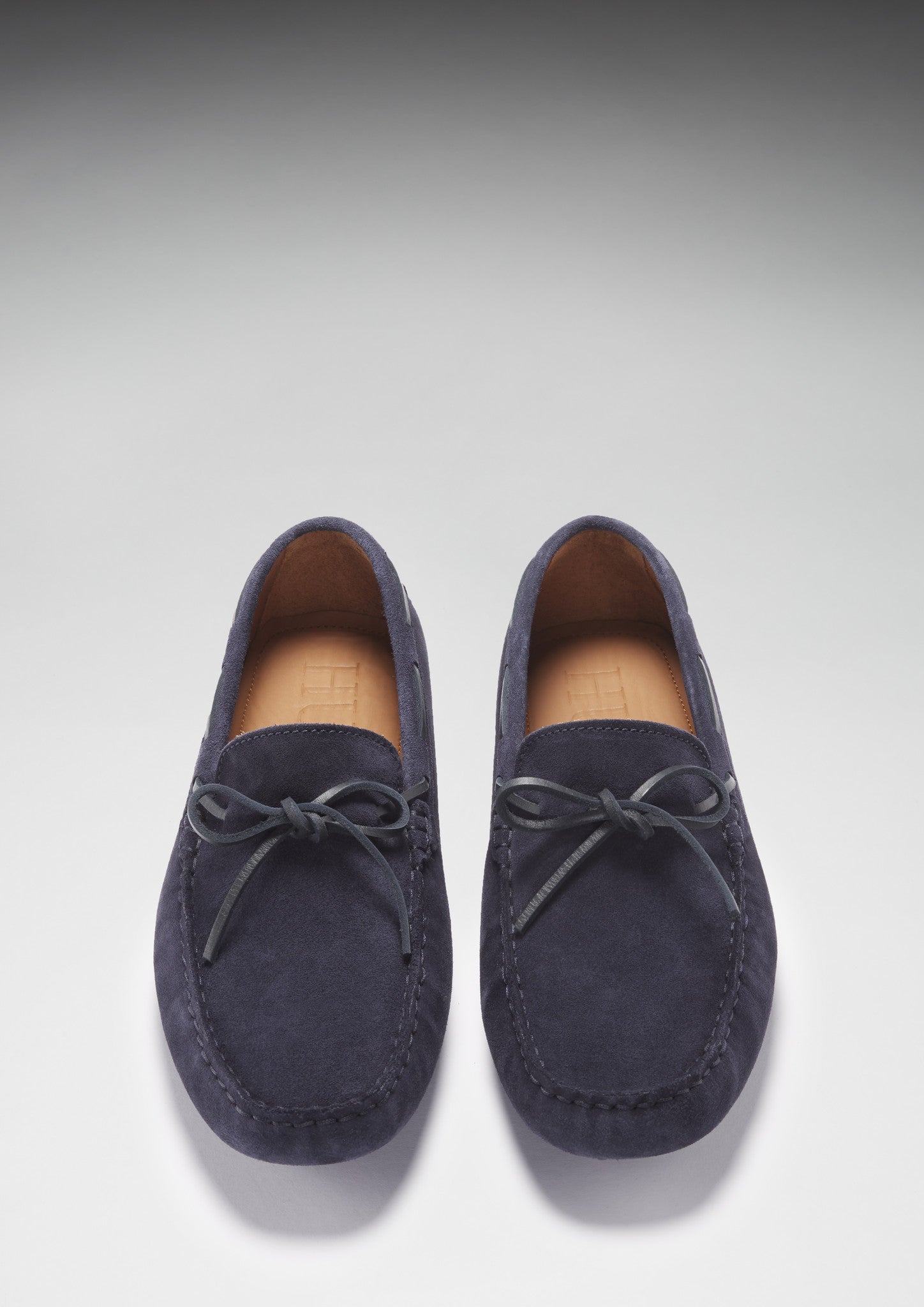 Pair of navy blue loafers on a light gray background