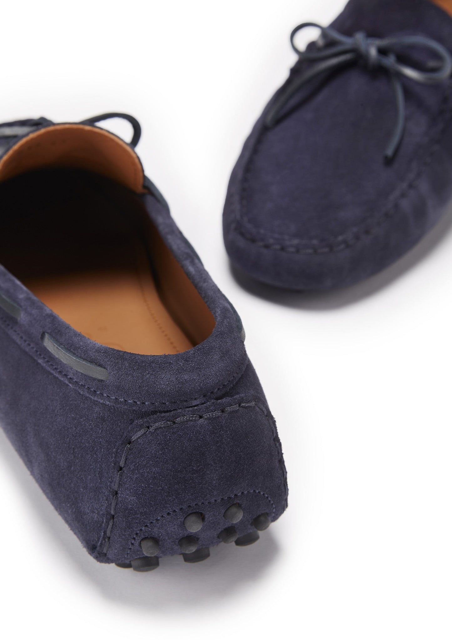Navy blue loafers with brown soles on a white background
