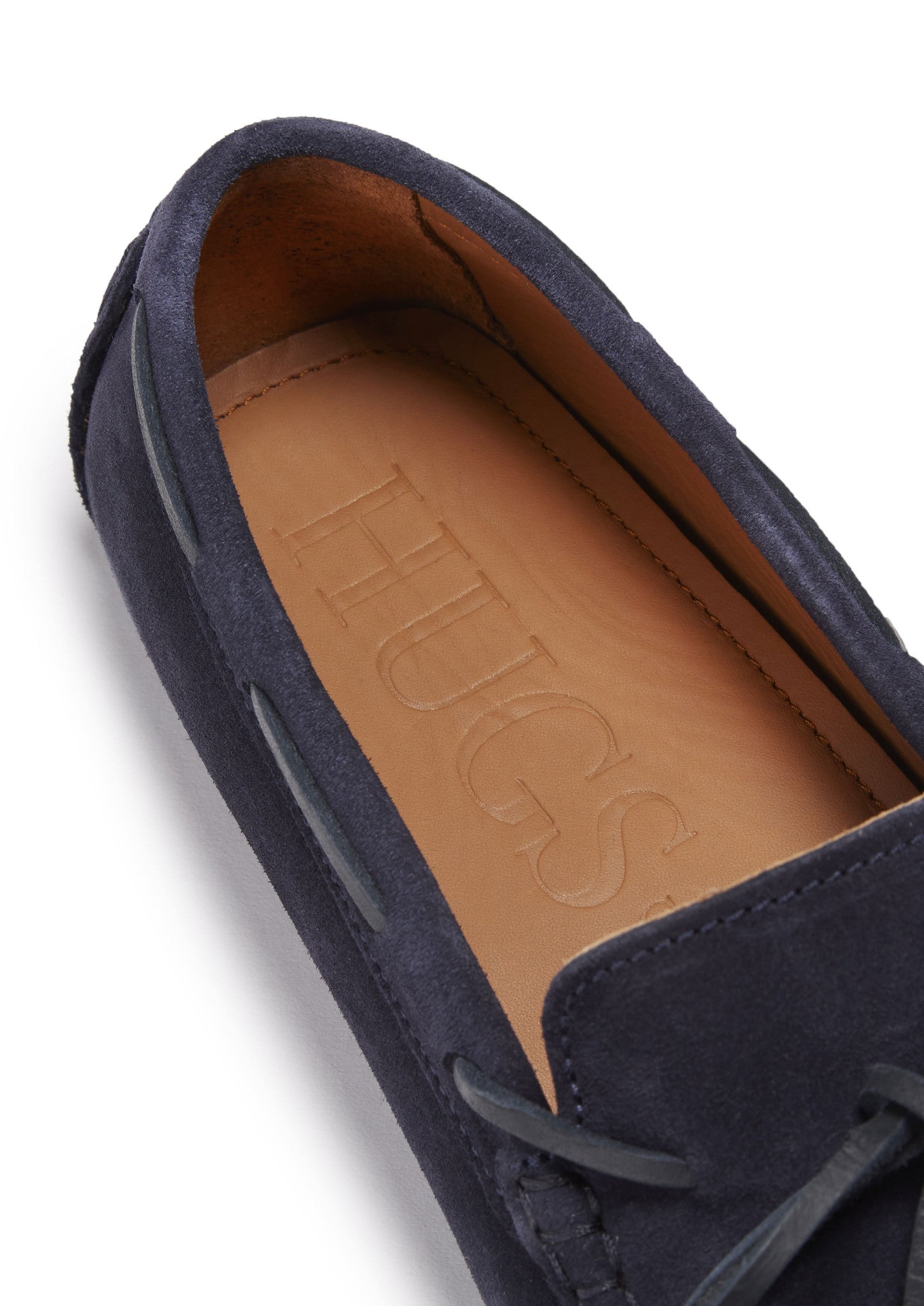 Navy blue loafer with tan interior showing 'HUGS' branding on a white background