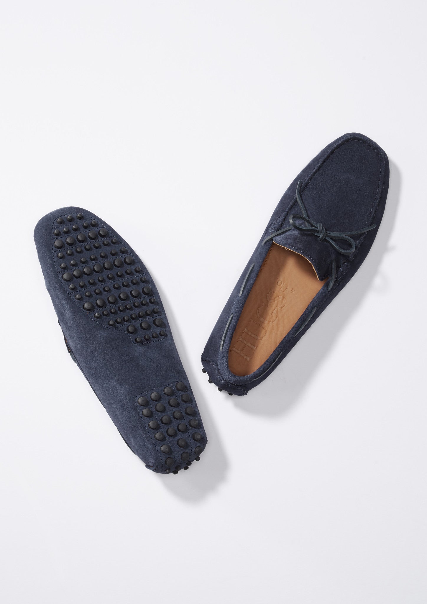 Pair of navy blue loafers with a bow on a white background