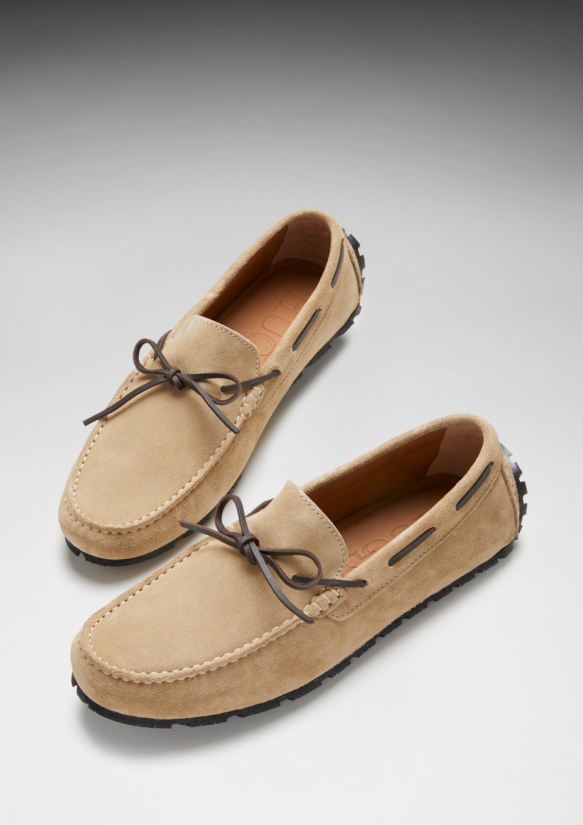 Pair of tan loafers on a gray background