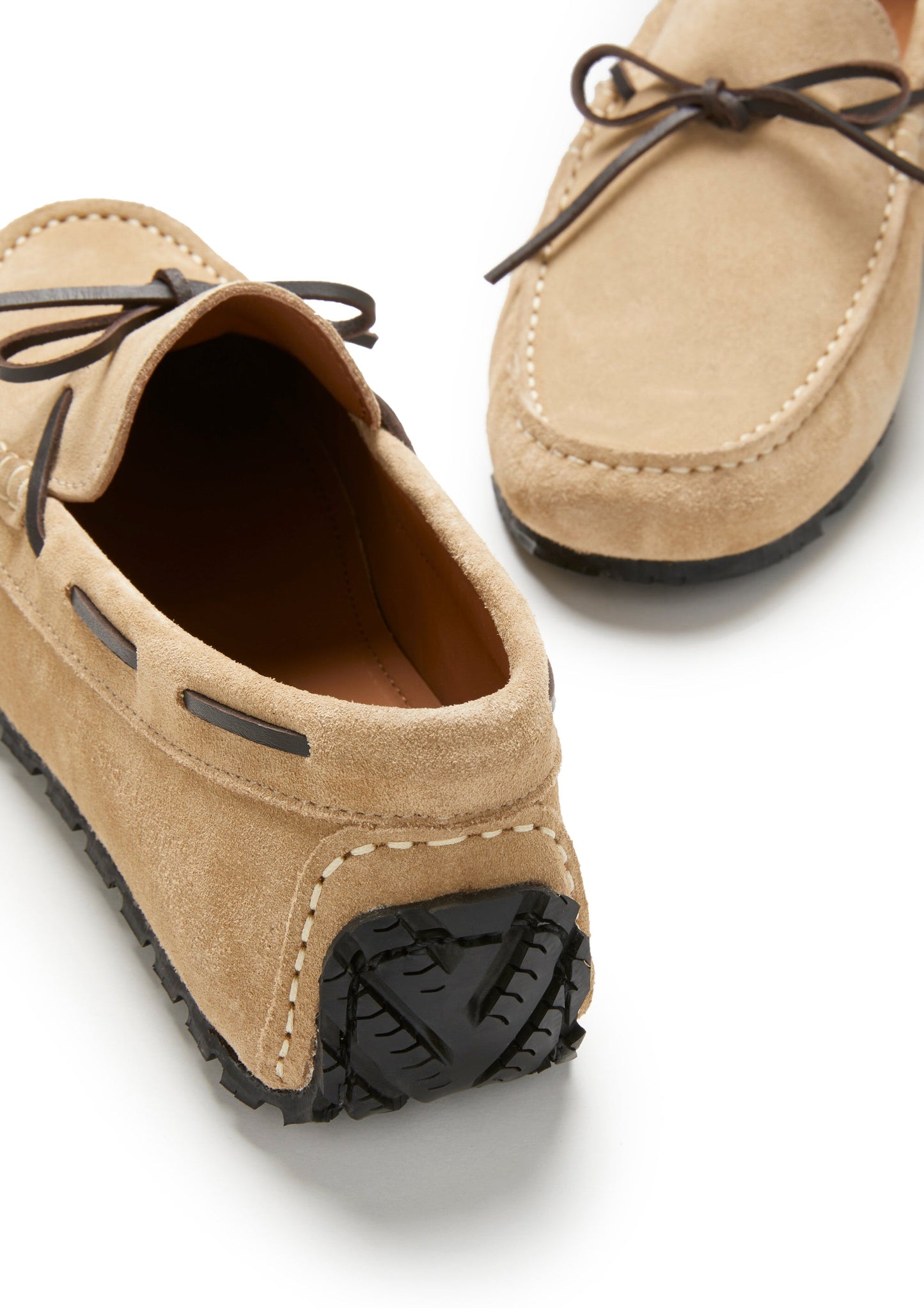 Pair of tan loafers with black soles on a white background